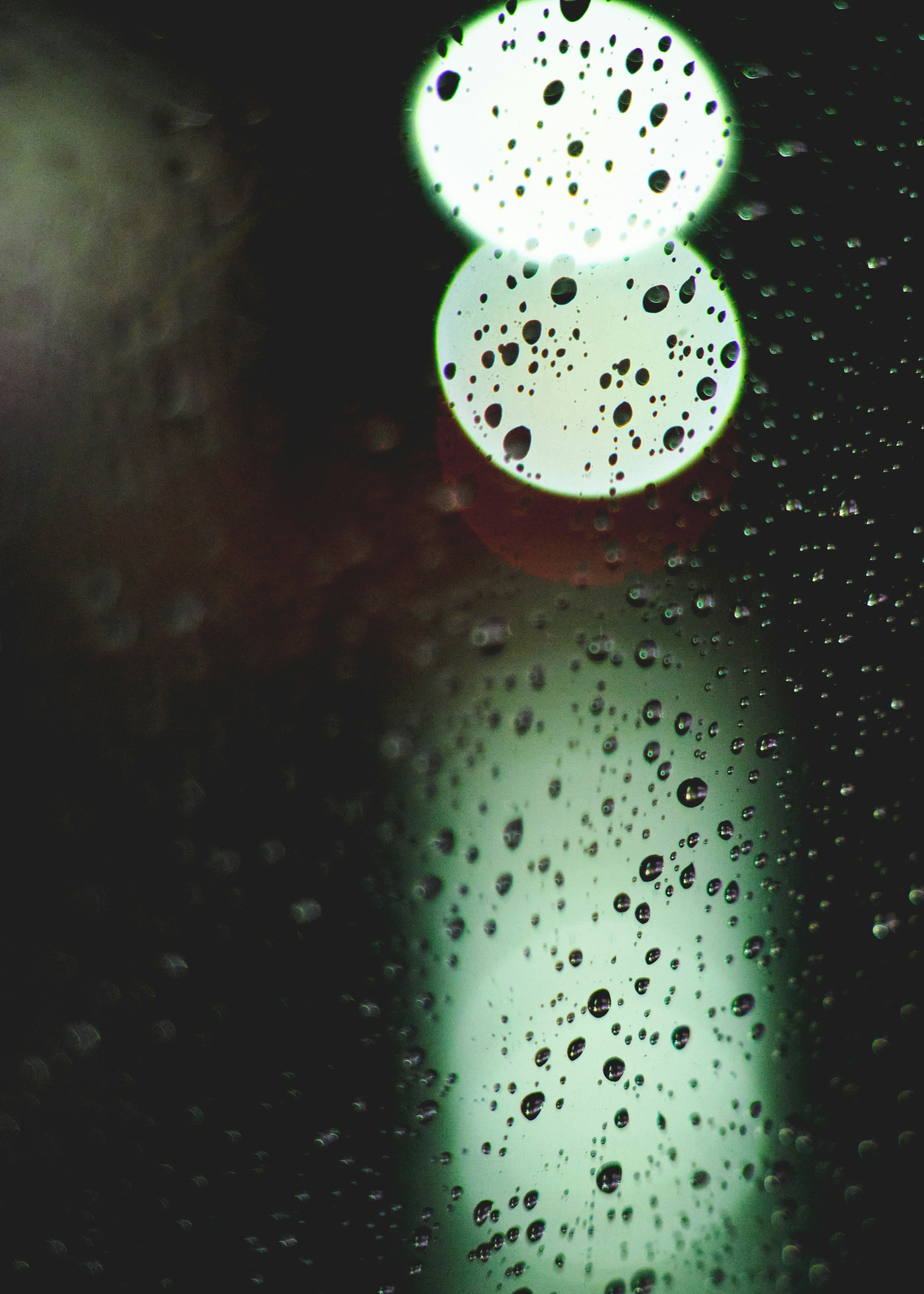 Giọt mưa trên kính với hiệu ứng bokeh ánh sáng màu xanh