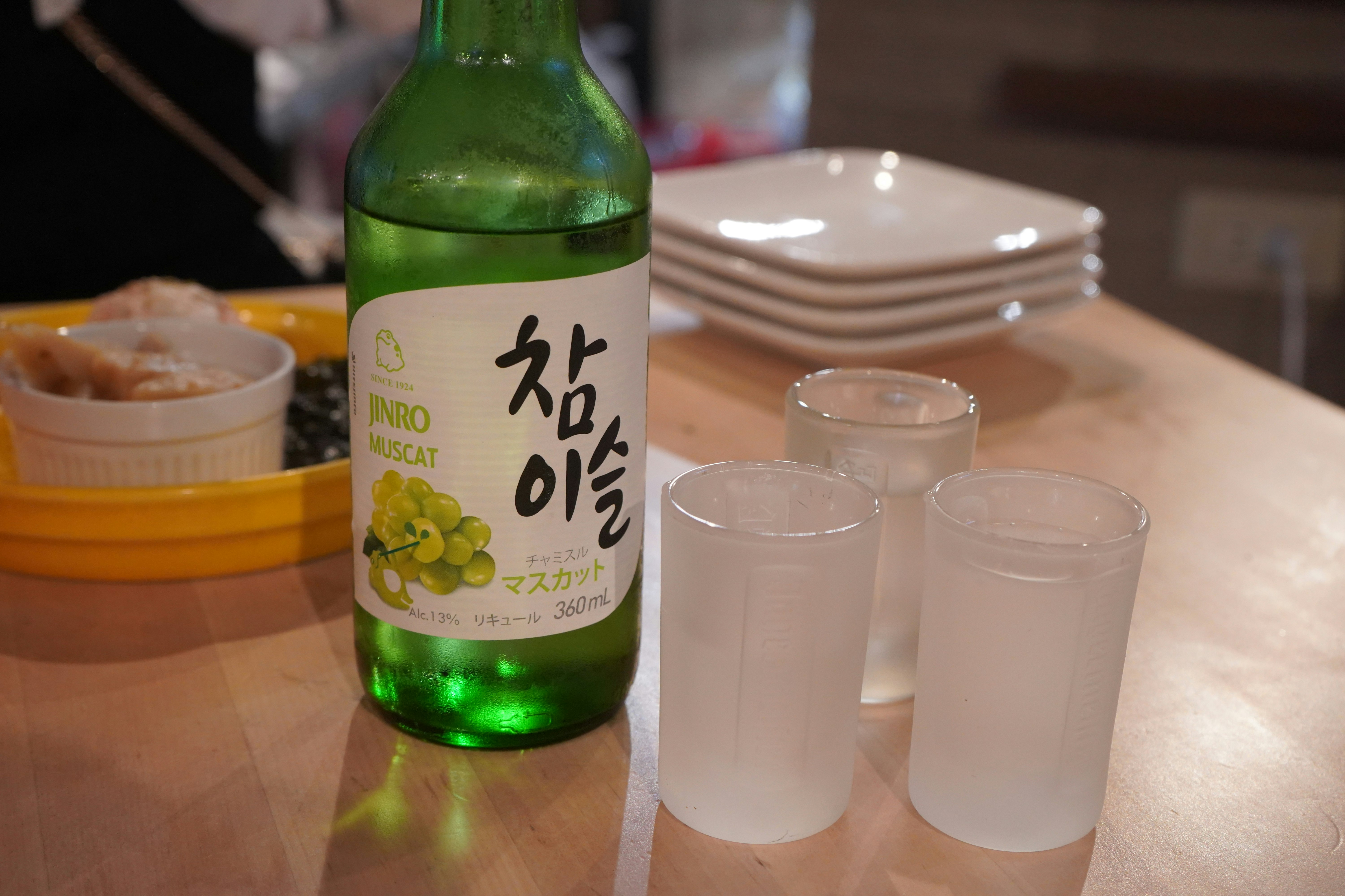 green bottle and glasses on a dining table