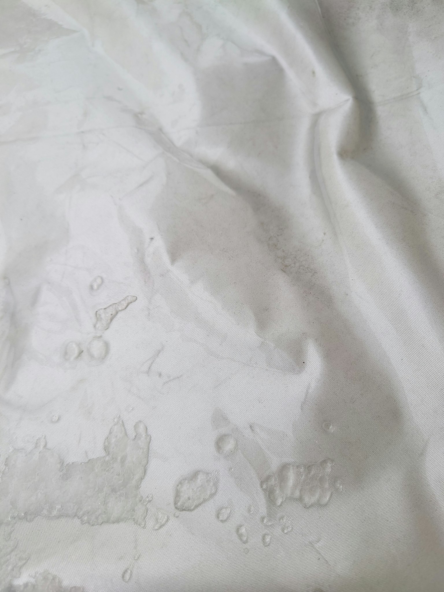 Image d'un tissu blanc avec des gouttes d'eau montrant une texture douce