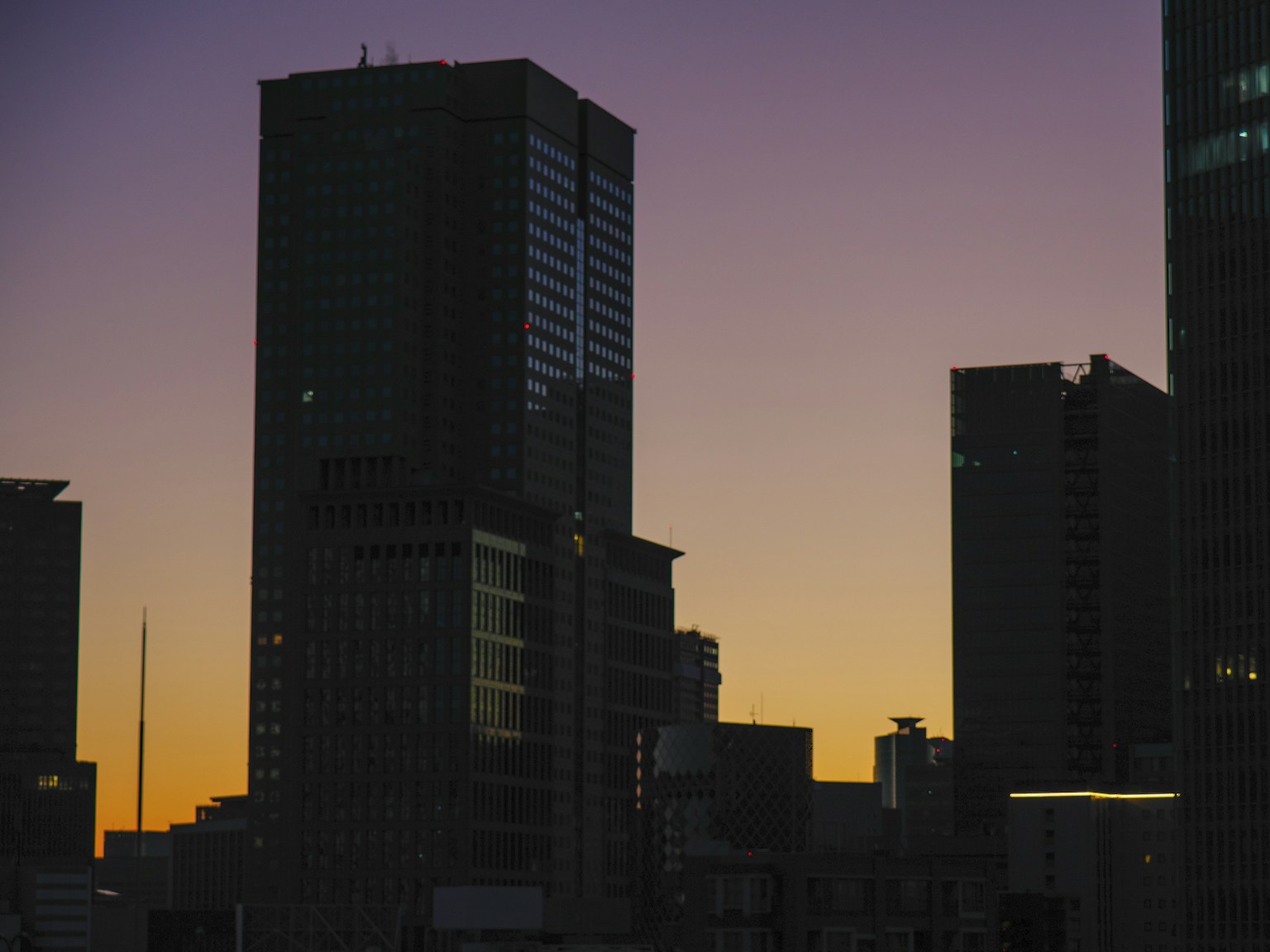 Silhouette of skyscrapers against a sunset background