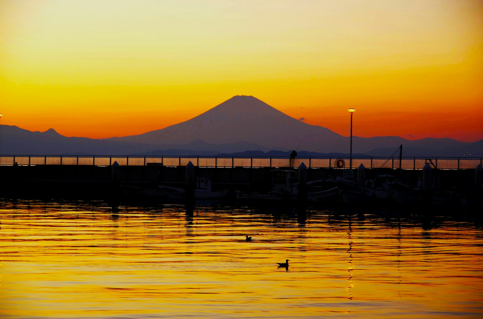 Vista del tramonto sul Monte Fuji con superficie d'acqua calma