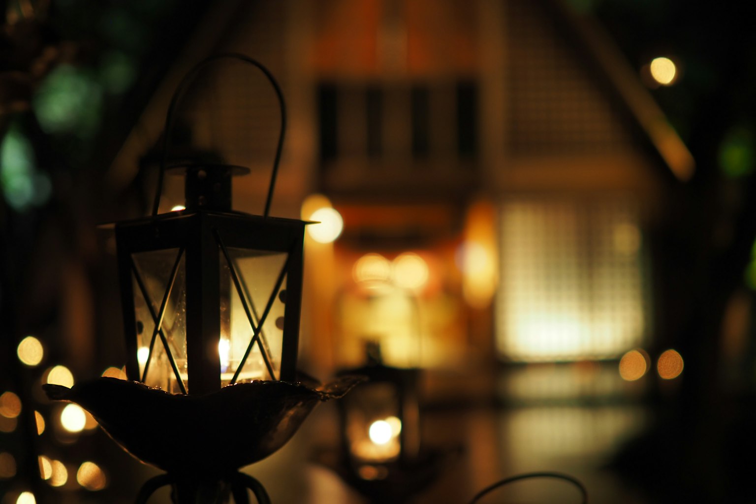 Night lantern illuminating a scene with a house in the background