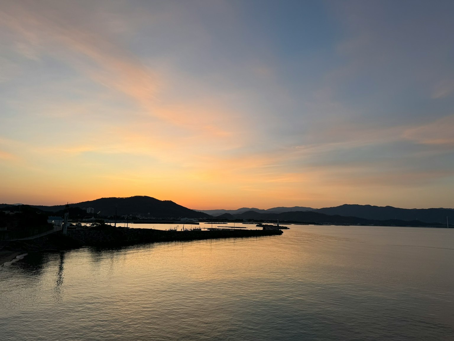 穏やかな海と美しい夕焼けの風景 山々が背景に広がる