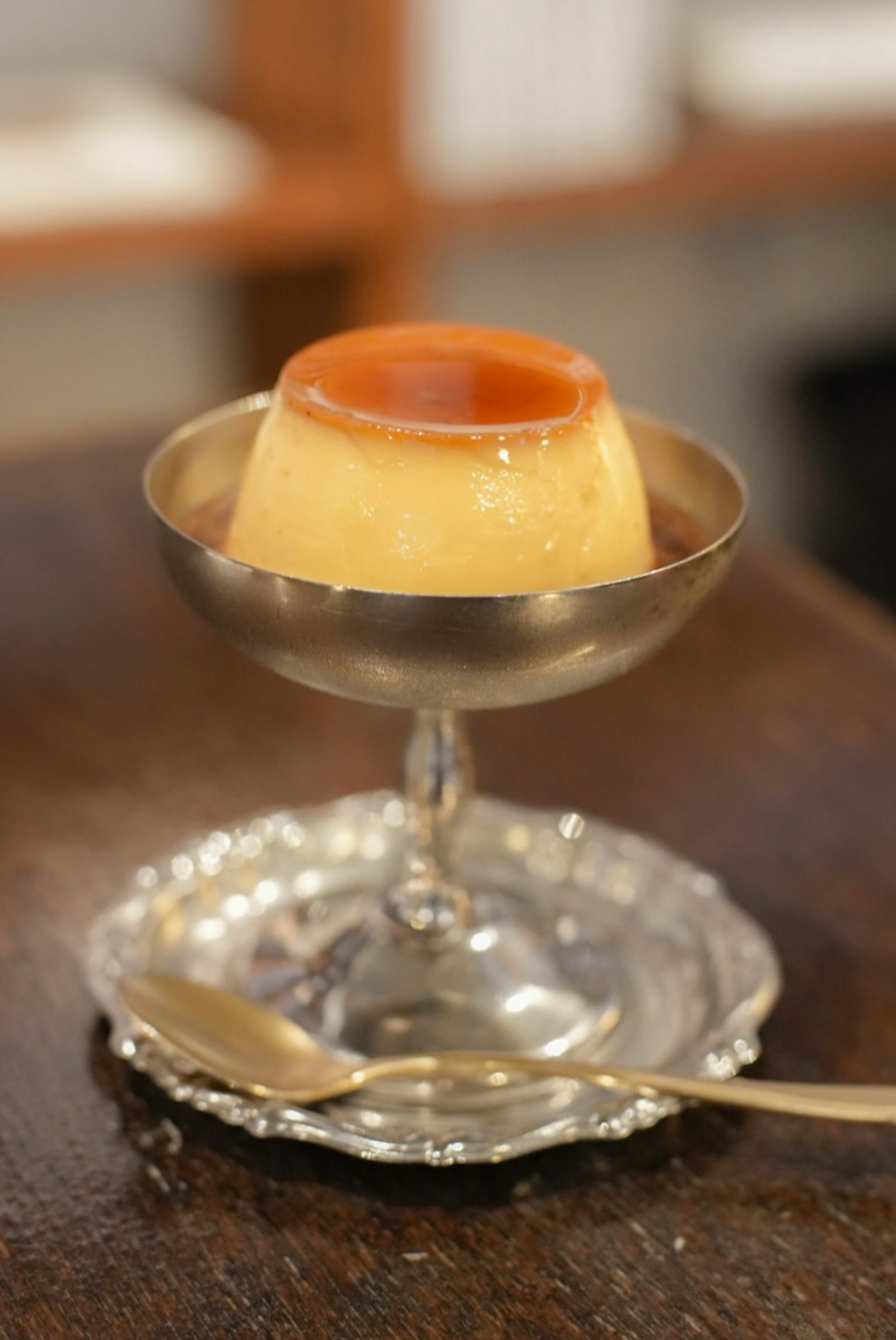 Budino cremoso servito in un piatto d'argento su un piatto decorativo