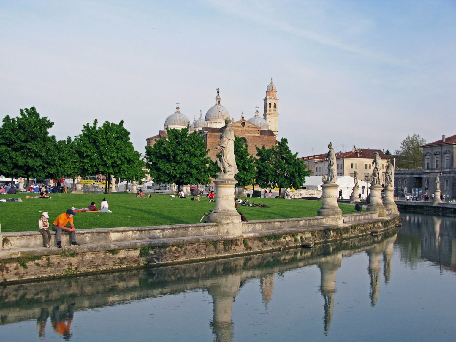 Vista panoramica di un parco lungo un fiume con chiesa a cupola sullo sfondo