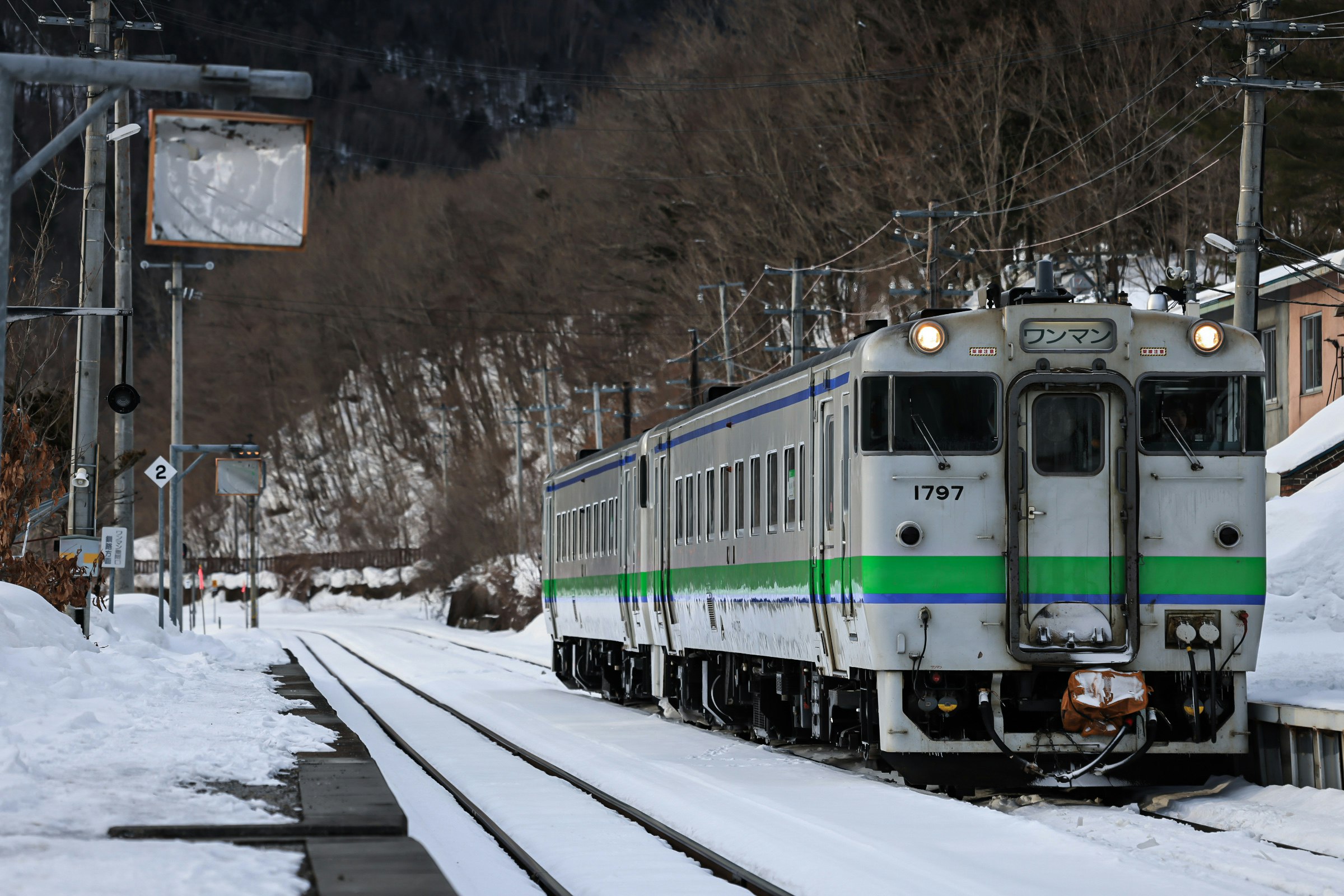 premier plan d’un train diesel roulant sur des voies enneigées