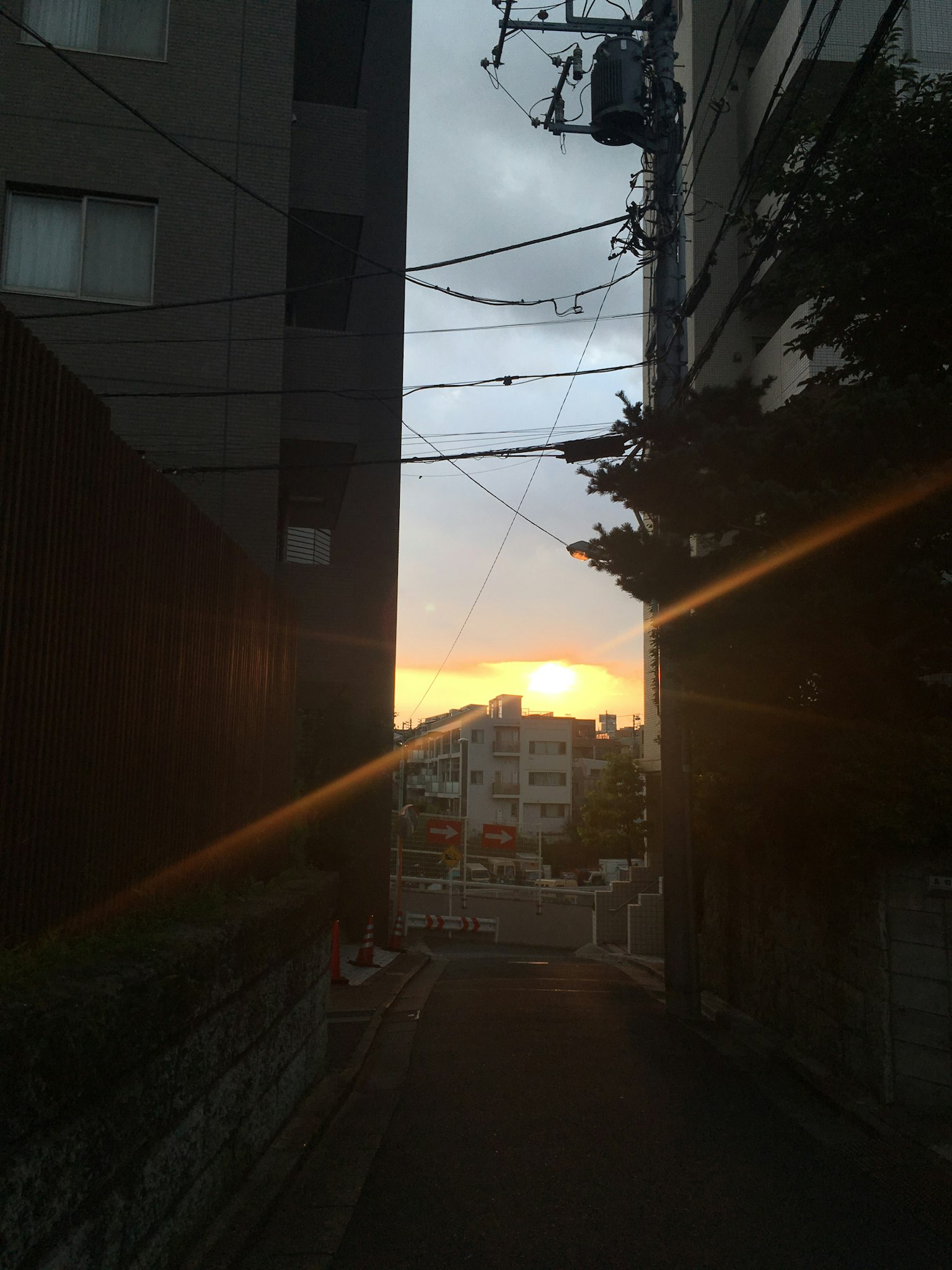 Narrow alley with a sunset visible at the end