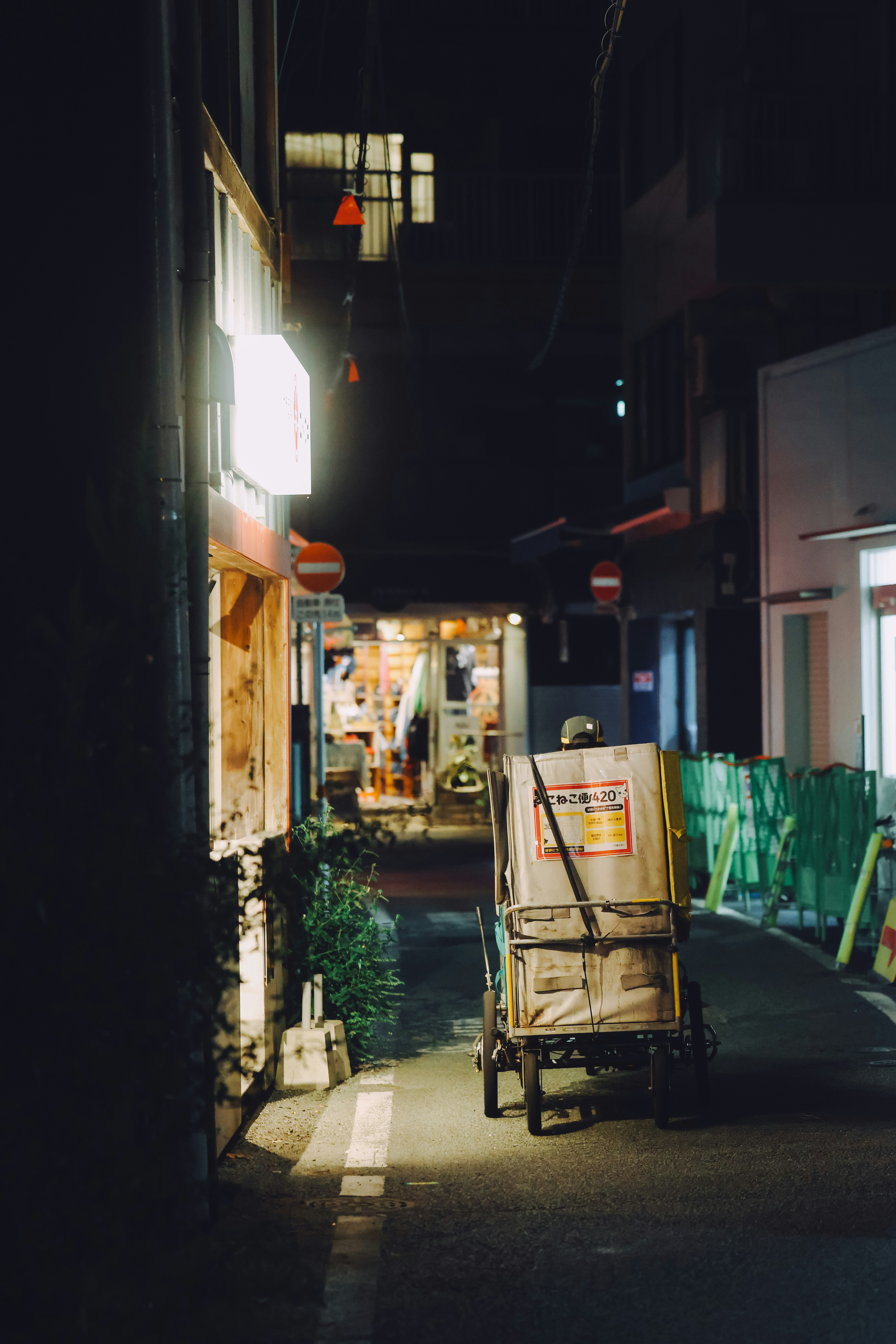 夜の路地裏で荷台の残る生活の影が漂う小径