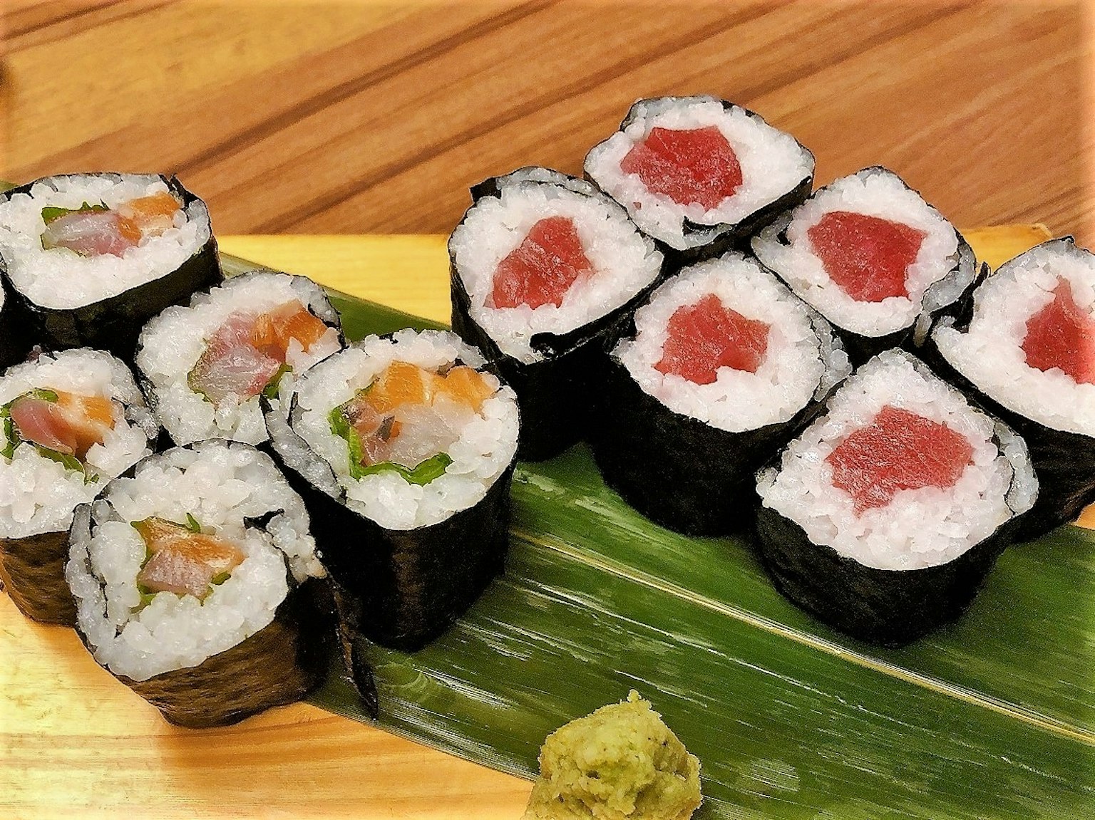 Sushi colorido dispuesto sobre una bandeja de madera