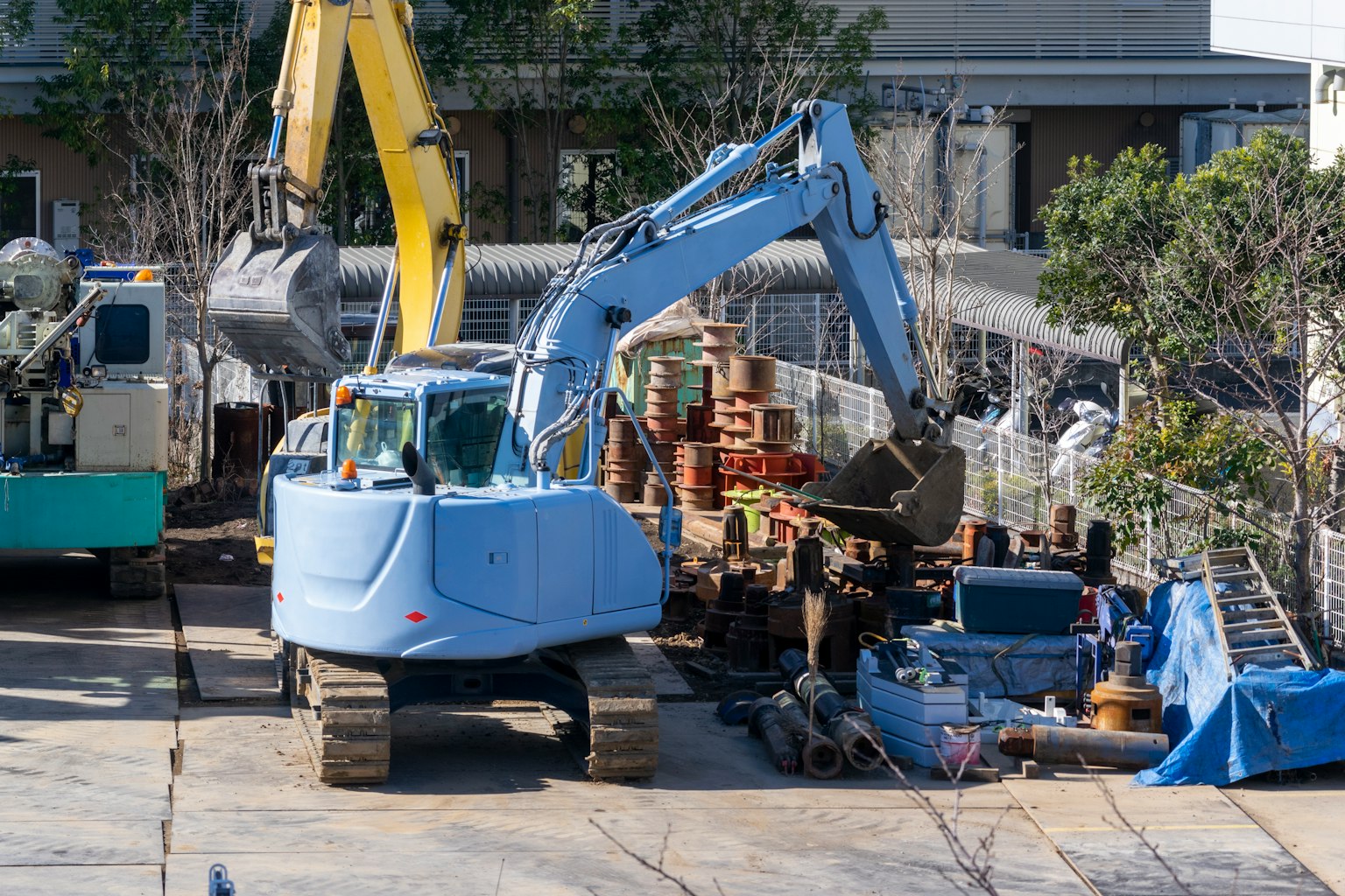 建築工地上的藍色挖土機和各種材料