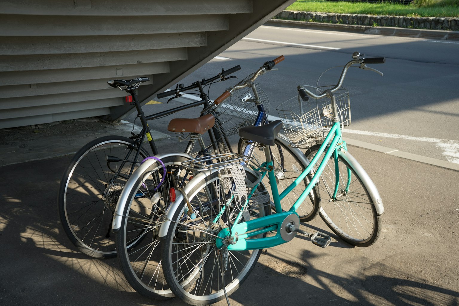 Tre biciclette parcheggiate sotto un riparo