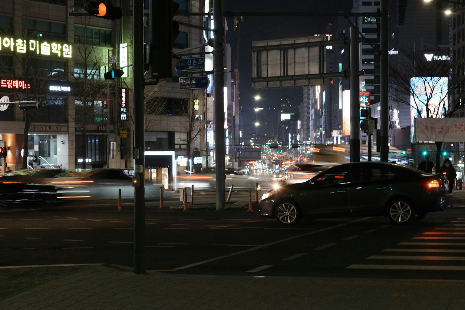 夜の都市風景 車の流れと明るい看板が特徴