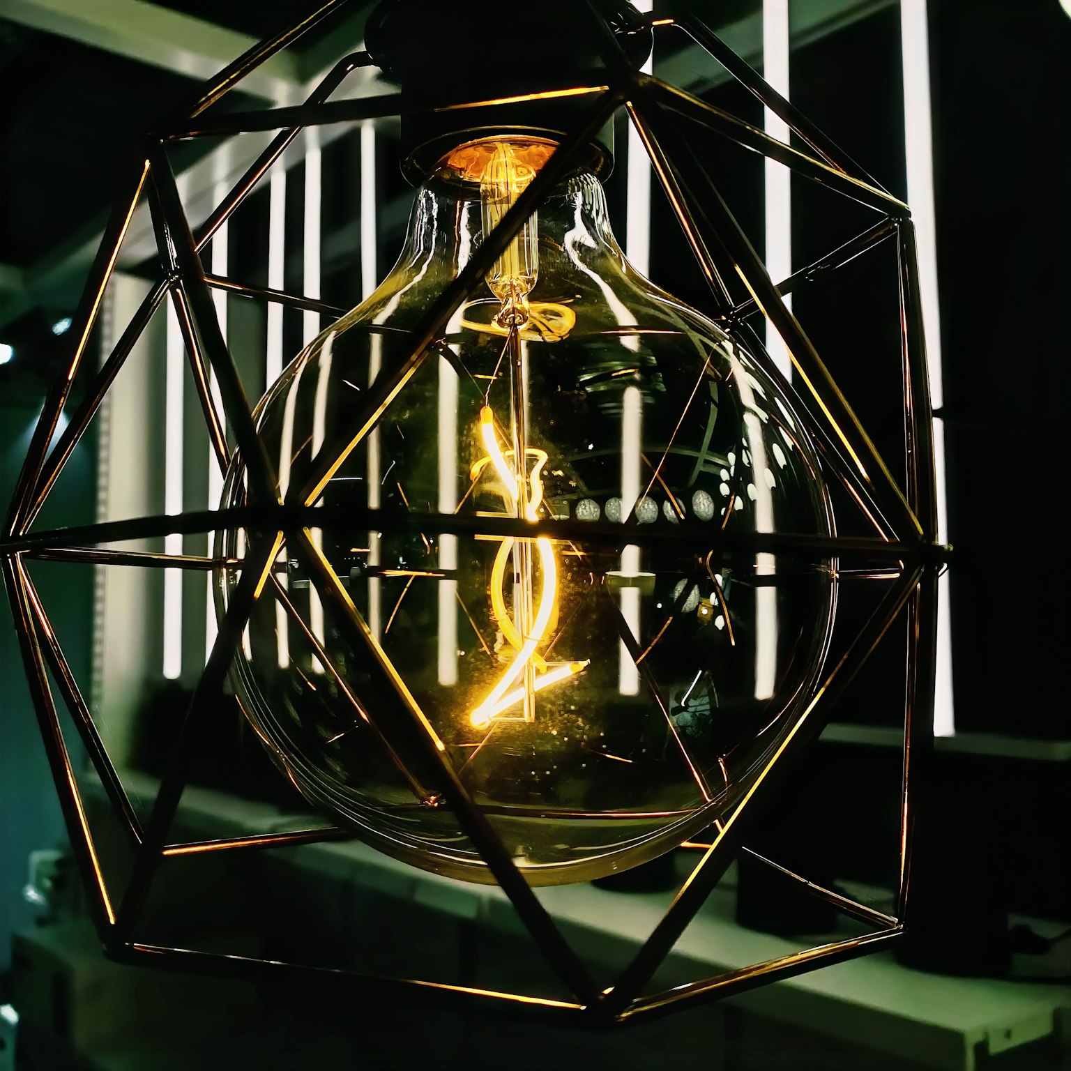 Glowing light bulb encased in a geometric lamp shade