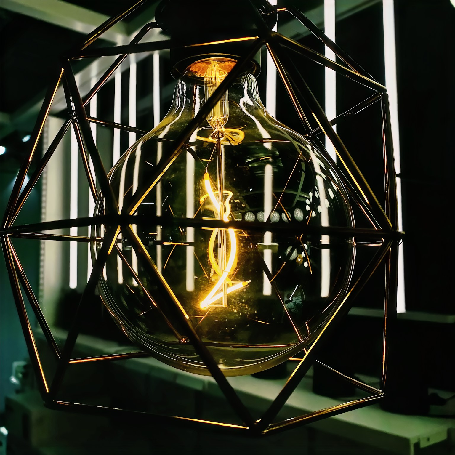 Bombilla brillante encerrada en una lámpara geométrica