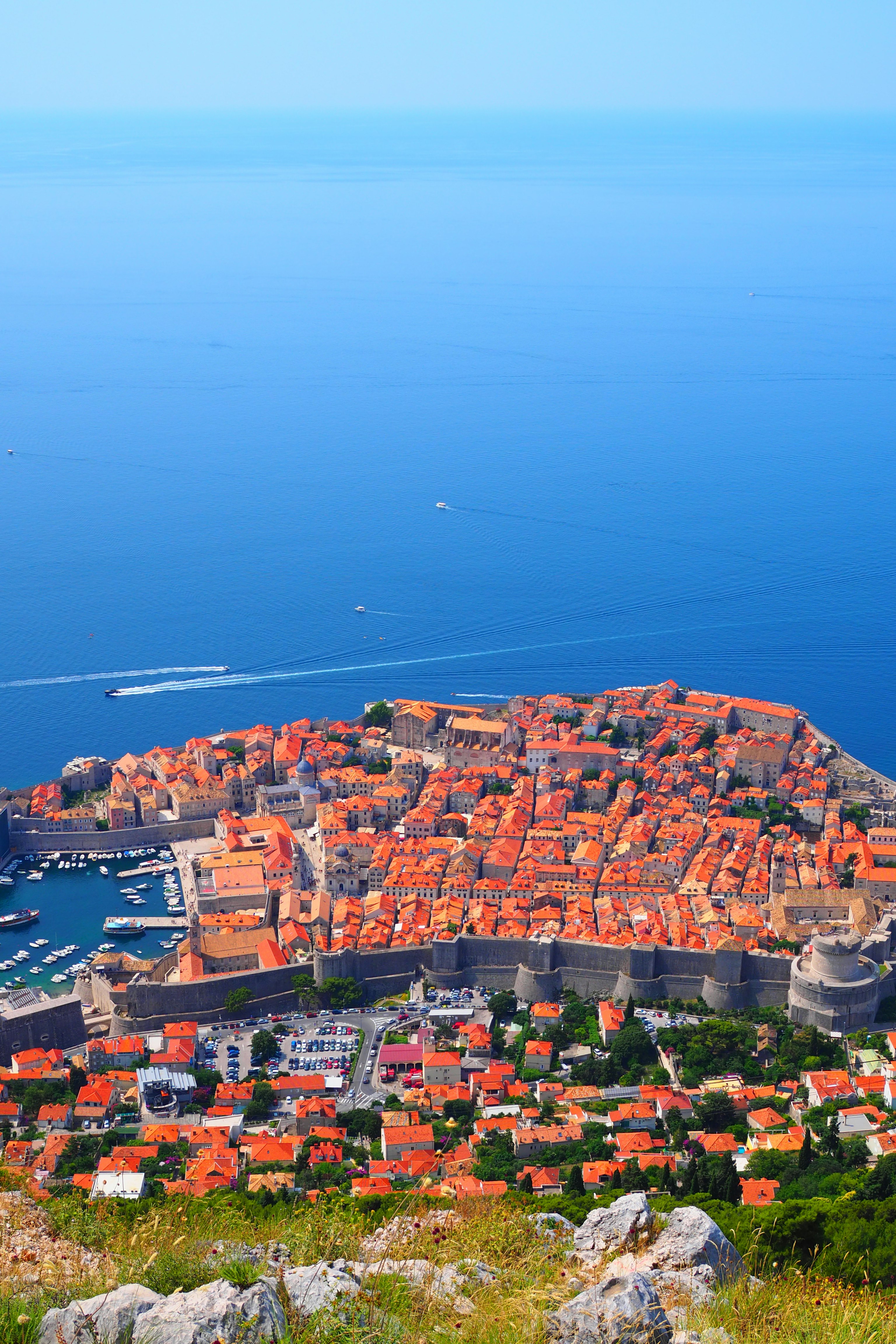 Aerial view of Dubrovnik with orange rooftops and blue sea