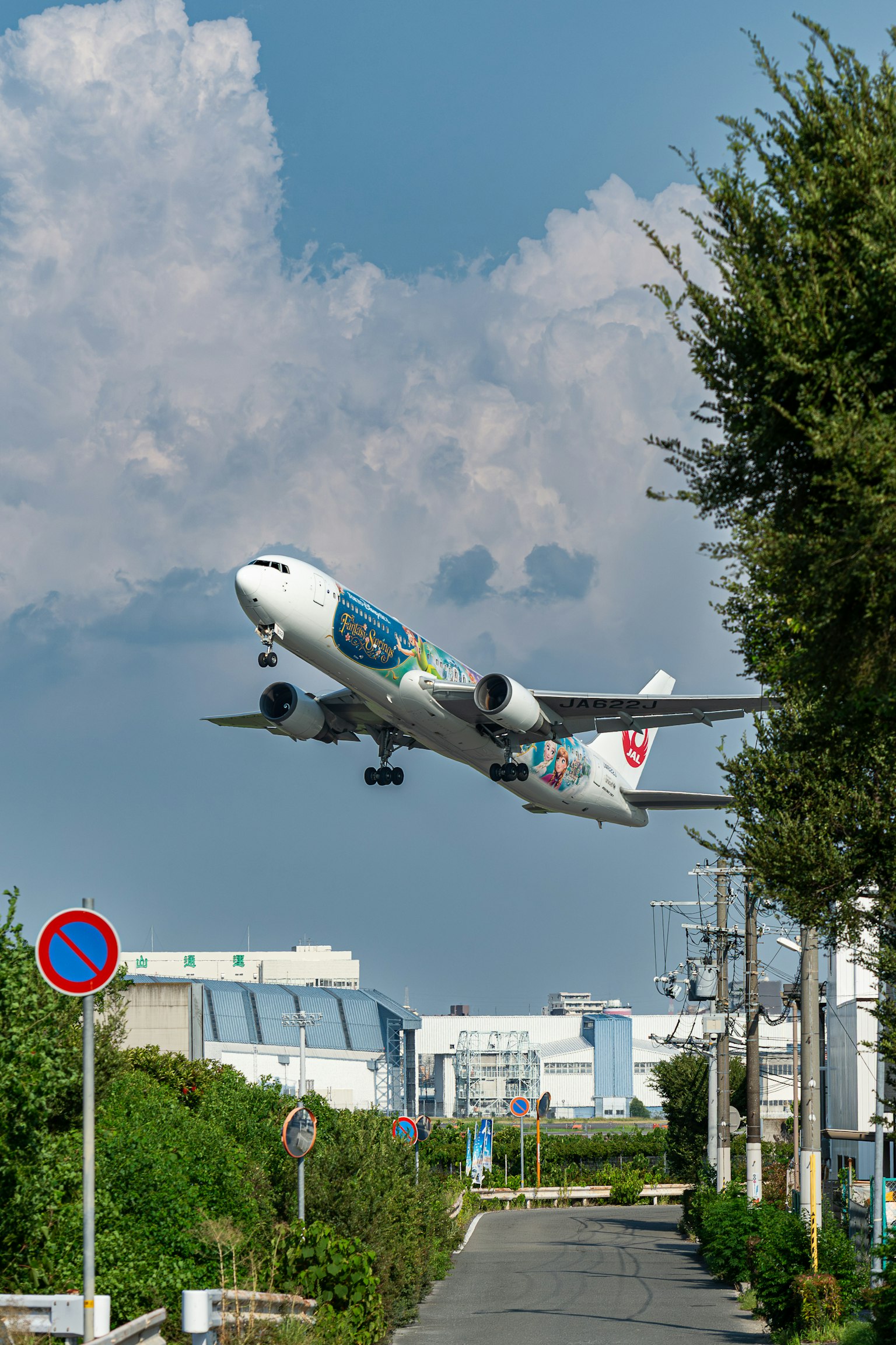 Sebuah pesawat lepas landas di latar belakang langit biru dengan awan putih