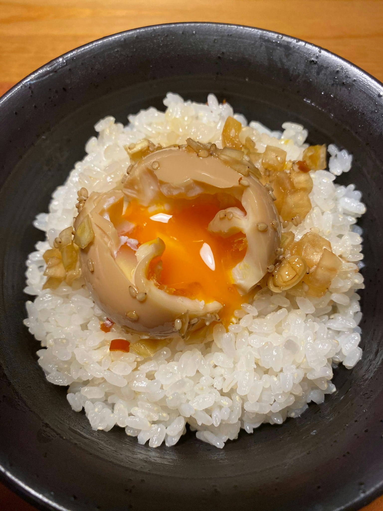 Un bol de riz blanc surmonté d'un œuf assaisonné et de sauce
