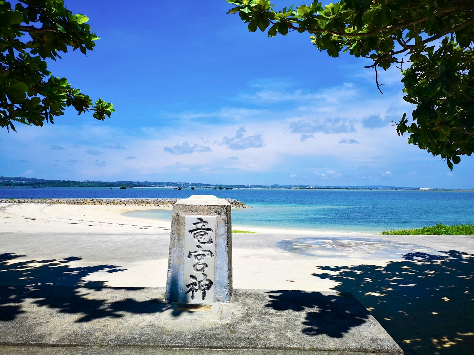 Pemandangan indah laut biru dan langit dengan pantai berpasir putih dan monumen batu