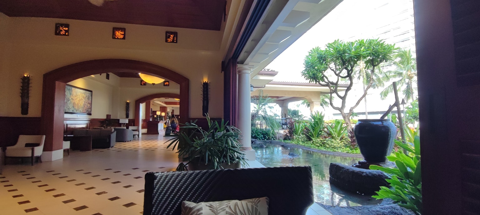 Spazioso lobby di un resort con piante interne e vista esterna sul verde
