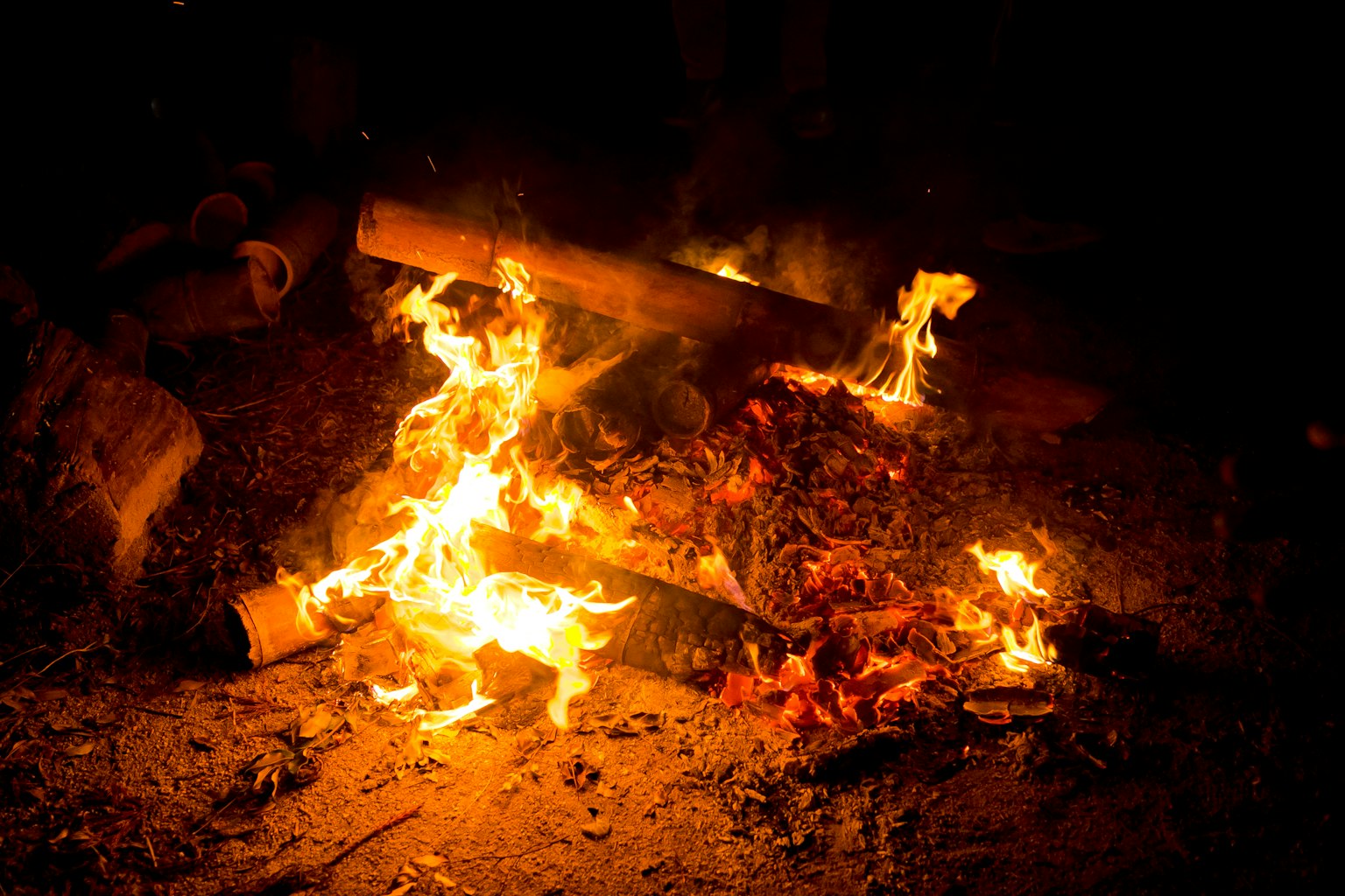 Flammen und Holzscheite brennen in der Dunkelheit
