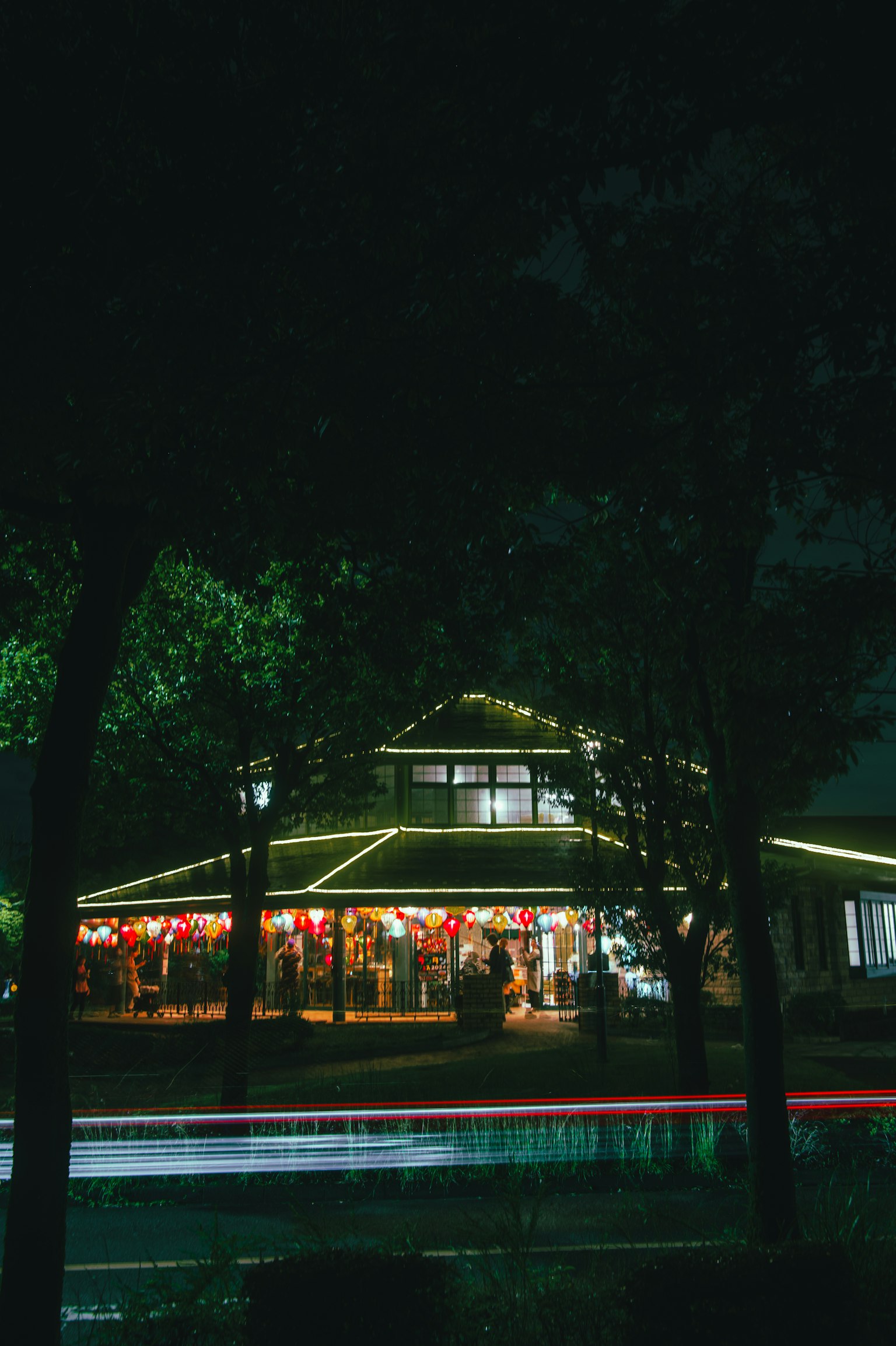 Edificio circolare illuminato di notte circondato da alberi