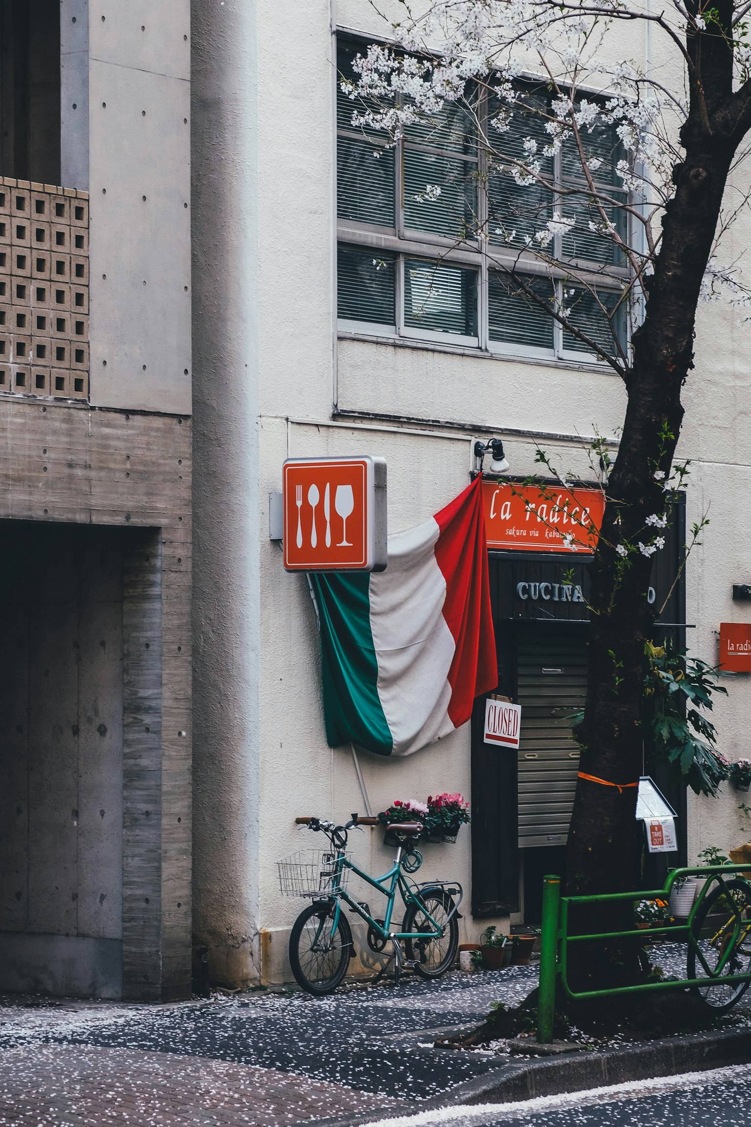 Extérieur d'un restaurant italien avec un drapeau et un vélo