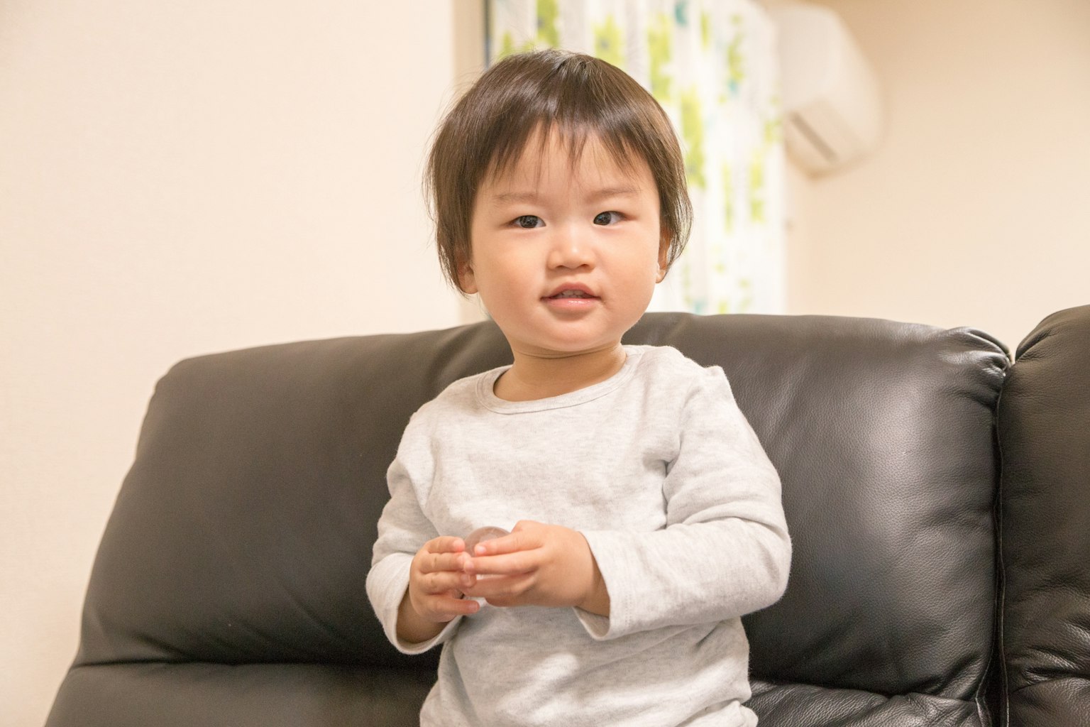 Un niño sentado en un sofá en un entorno interior brillante
