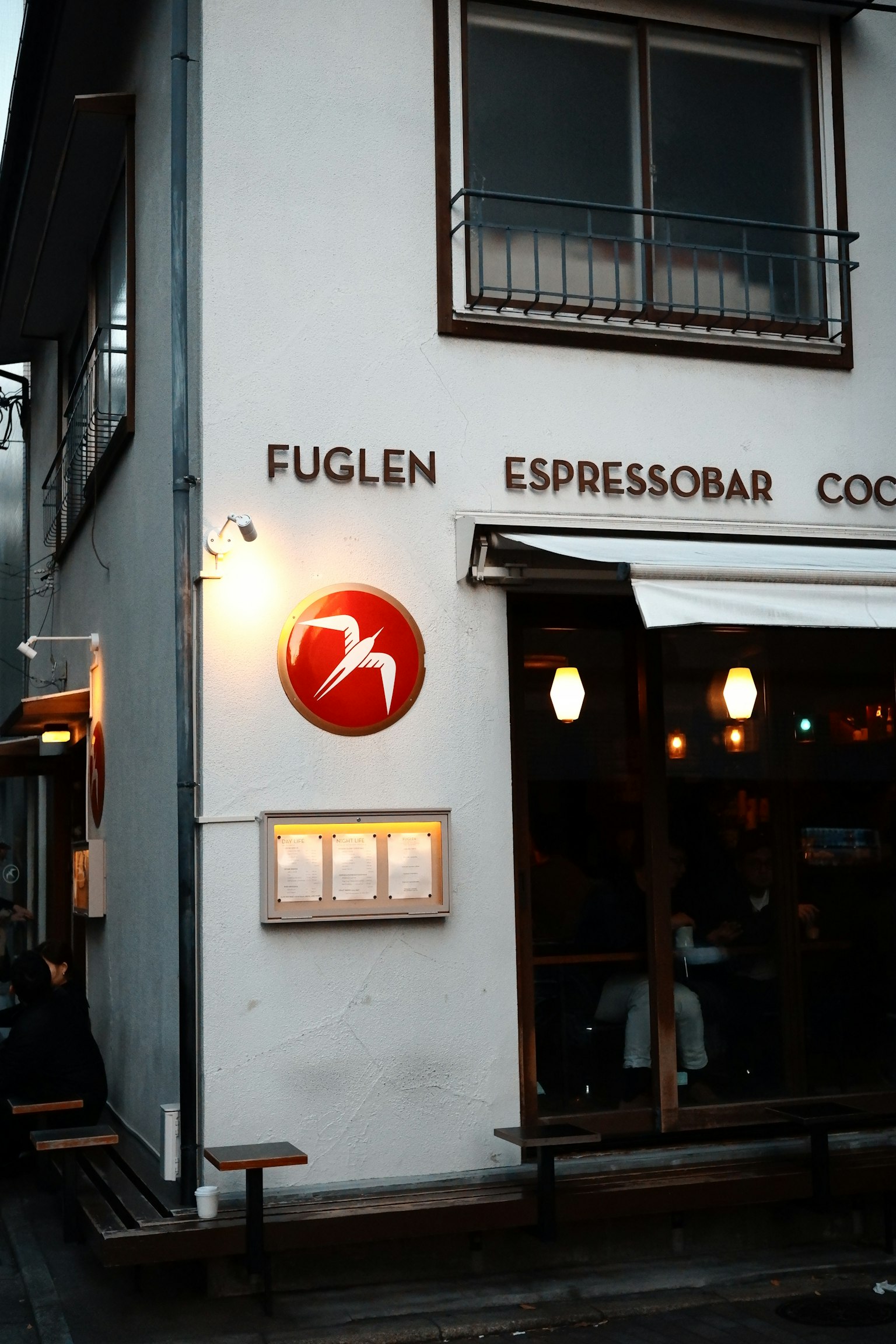 มุมมองภายนอกของคาเฟ่ Fuglen พร้อมโลโก้และเมนู