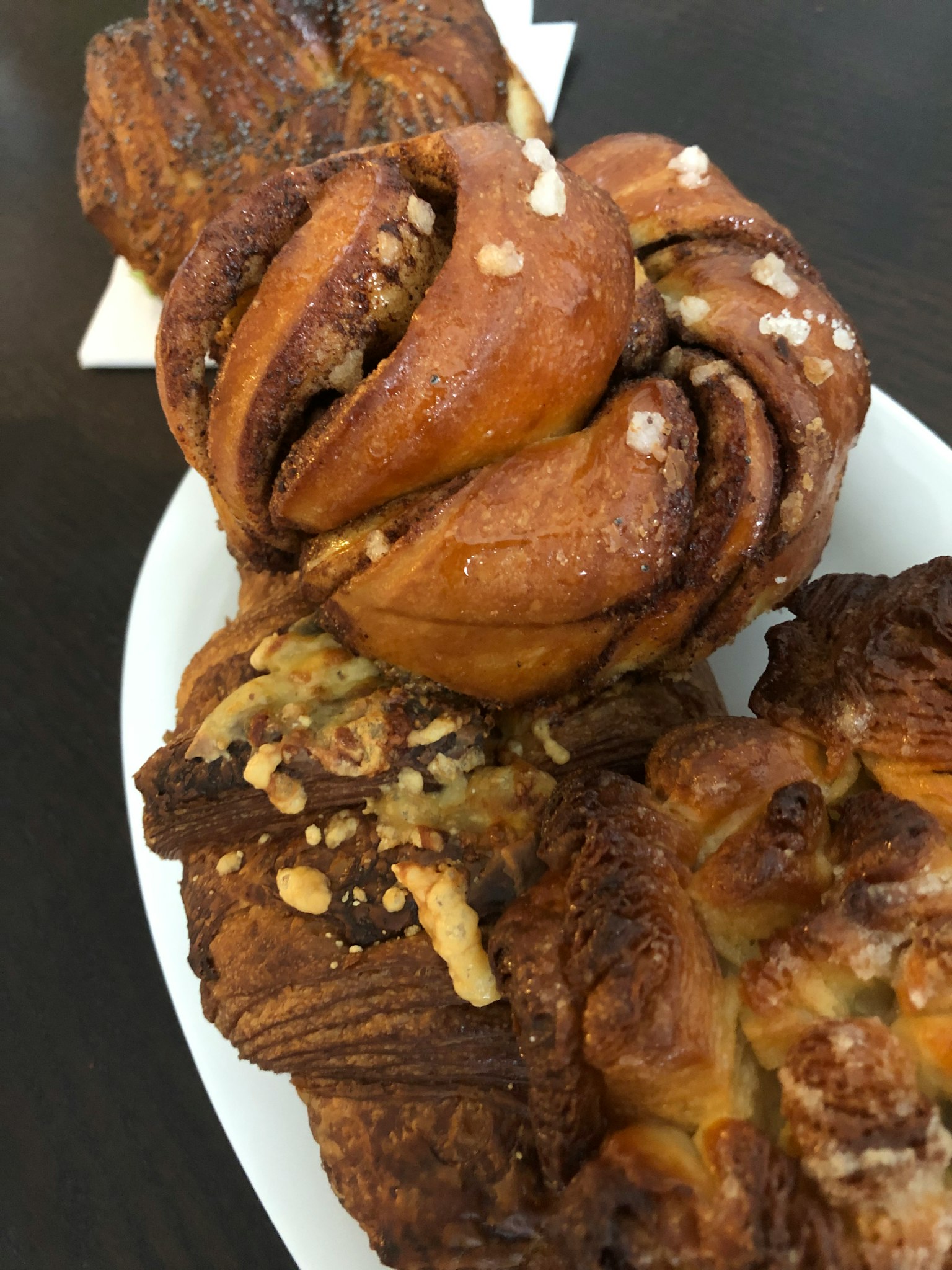 Zimtschnecken und Nussgebäck auf einem weißen Teller angerichtet