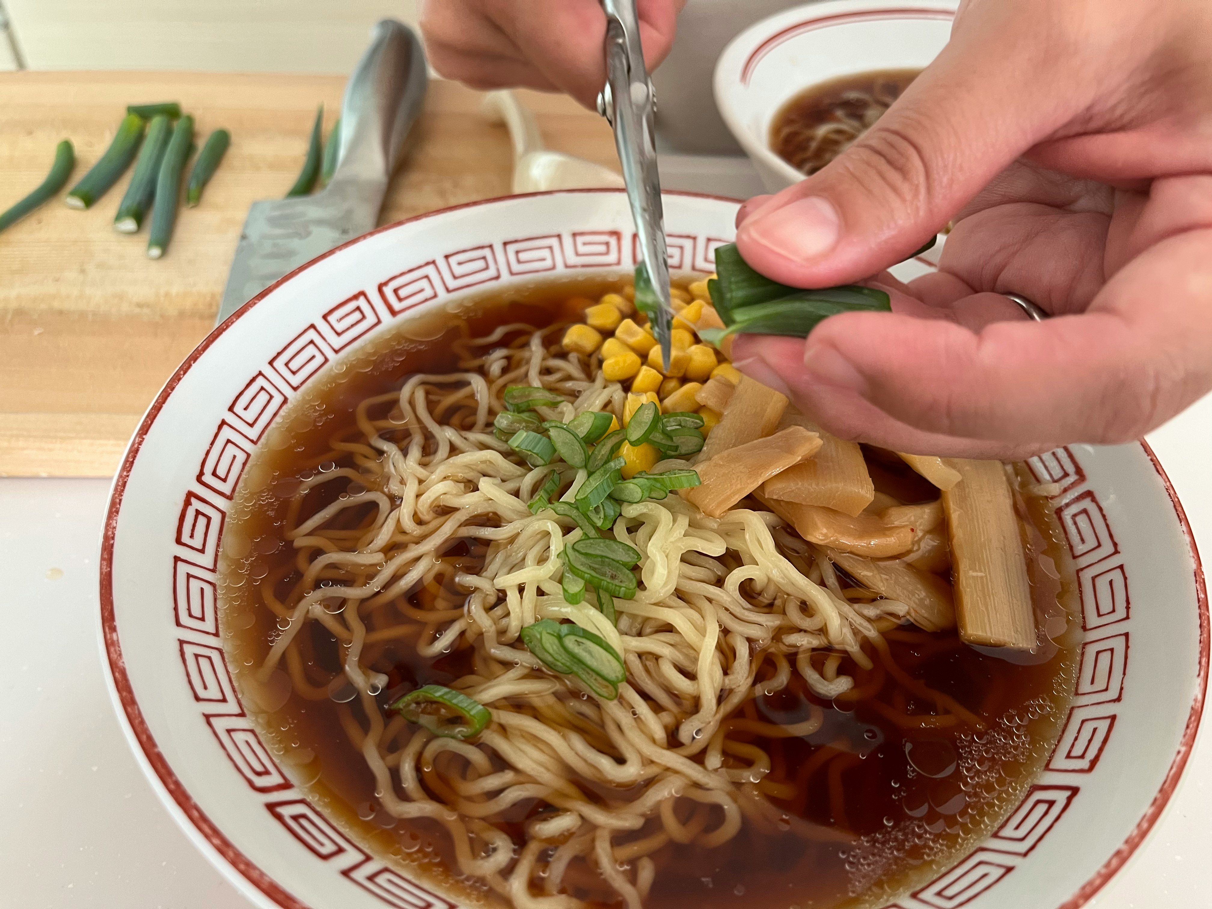 箸で具材をのせるラーメンの食卓