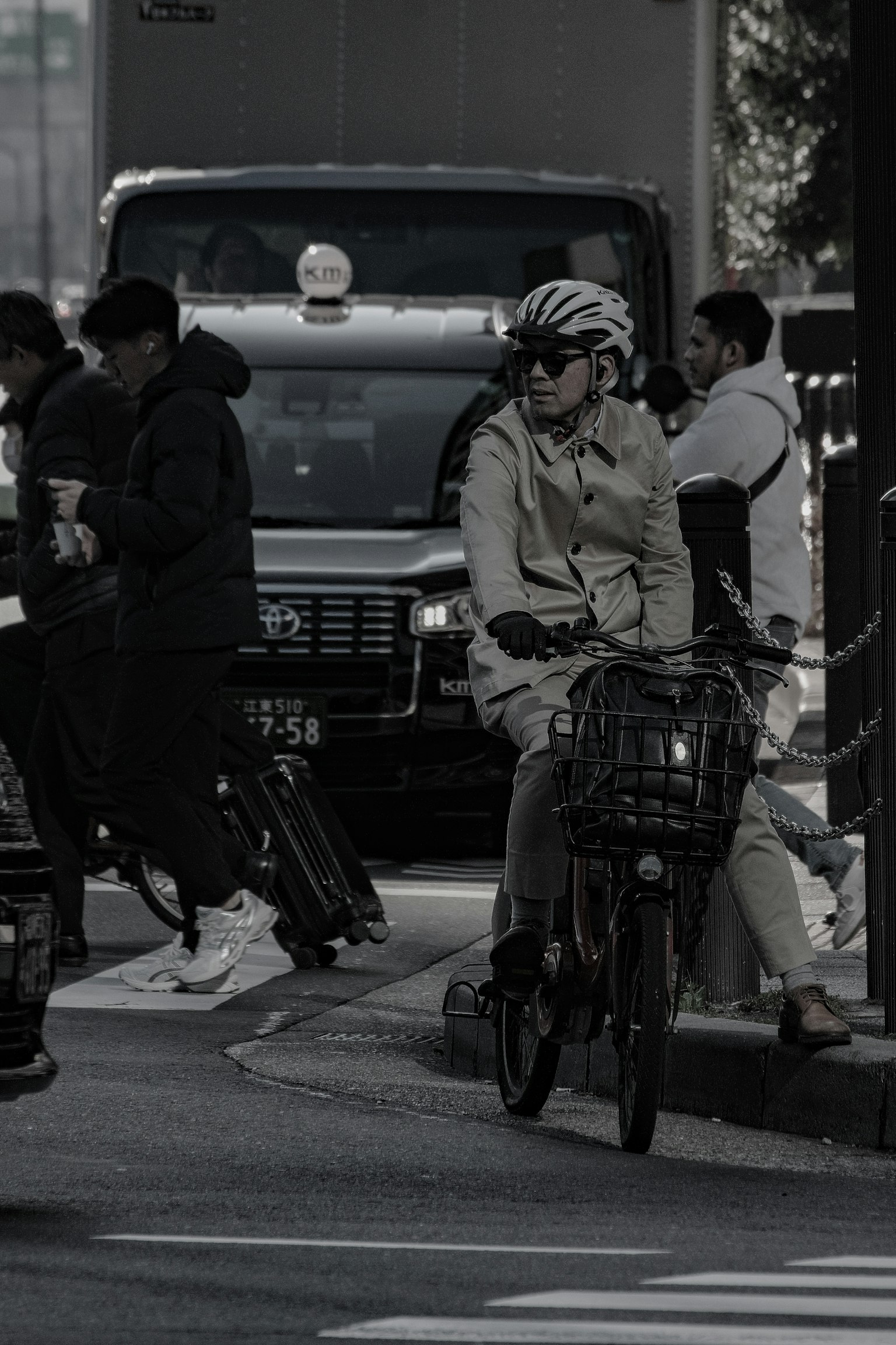 街頭で自転車に乗る女性が周囲の人々と交差している風景
