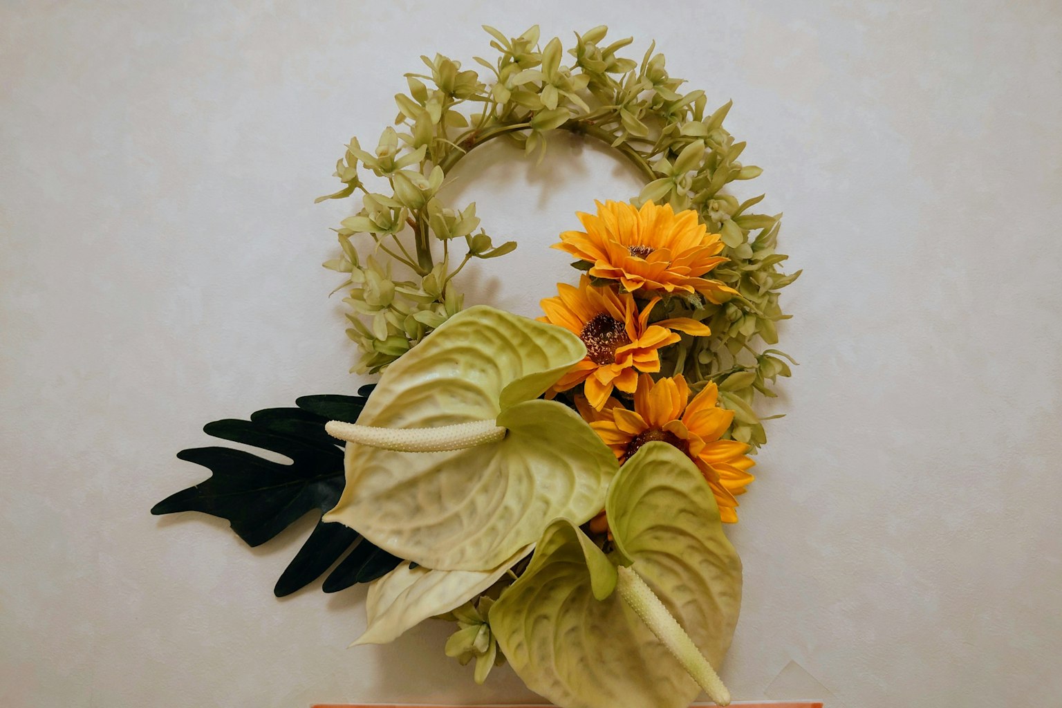 Bild eines mit grünen und gelben Blumen dekorierten Kranzes