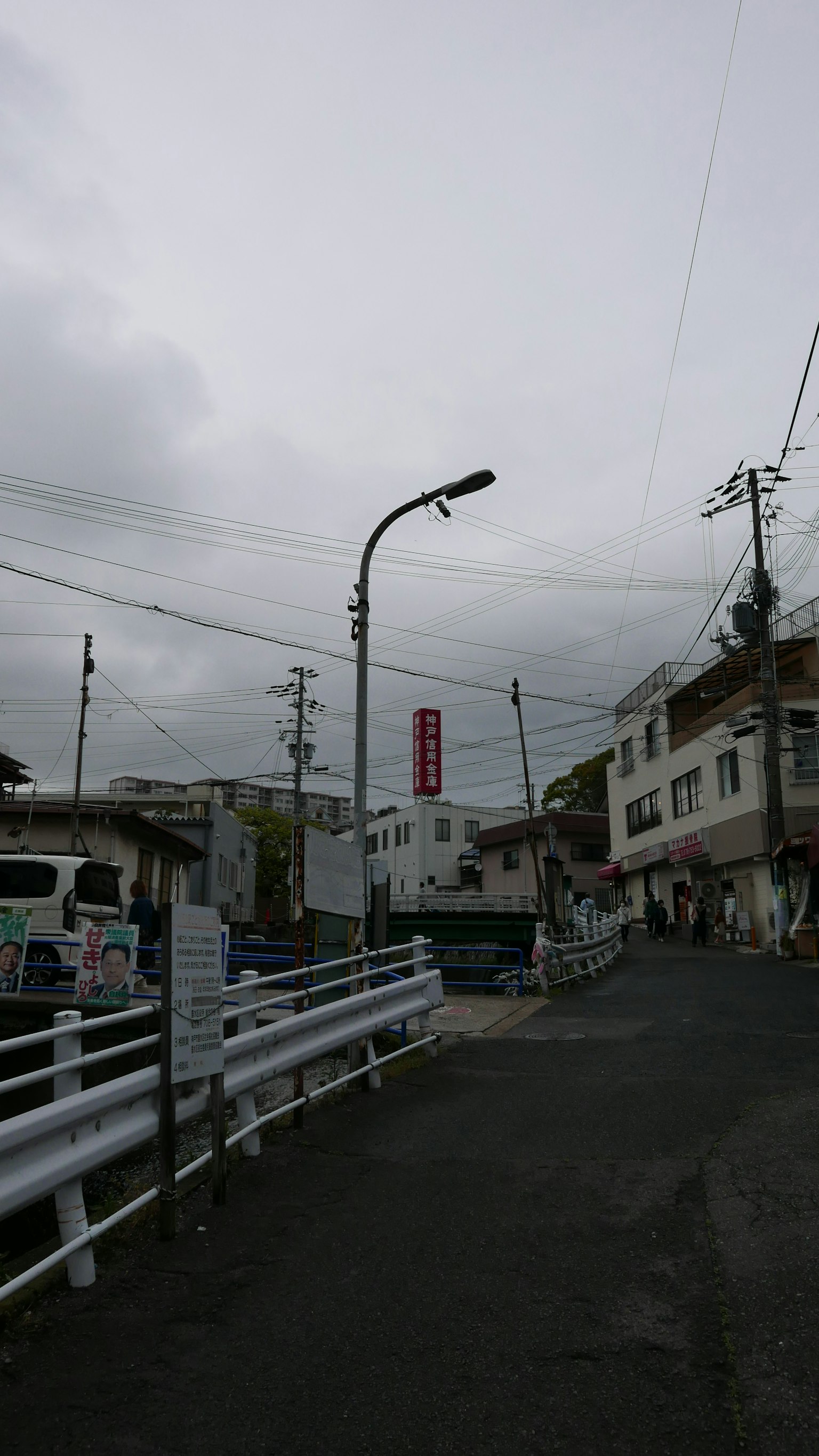 Street corner view under cloudy sky with white fence
