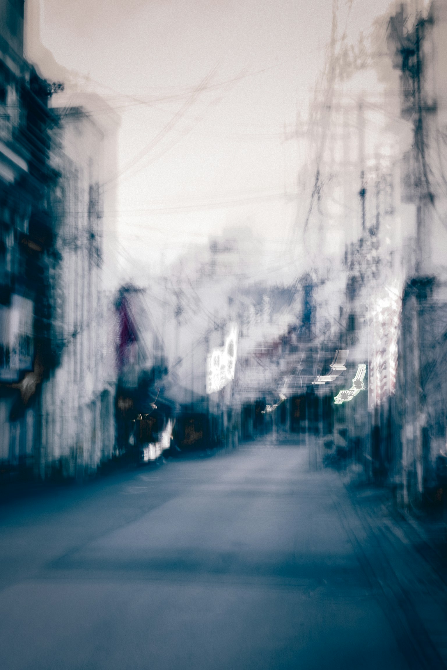 模糊的城市街景，昏暗的建筑和路灯营造出阴郁的氛围