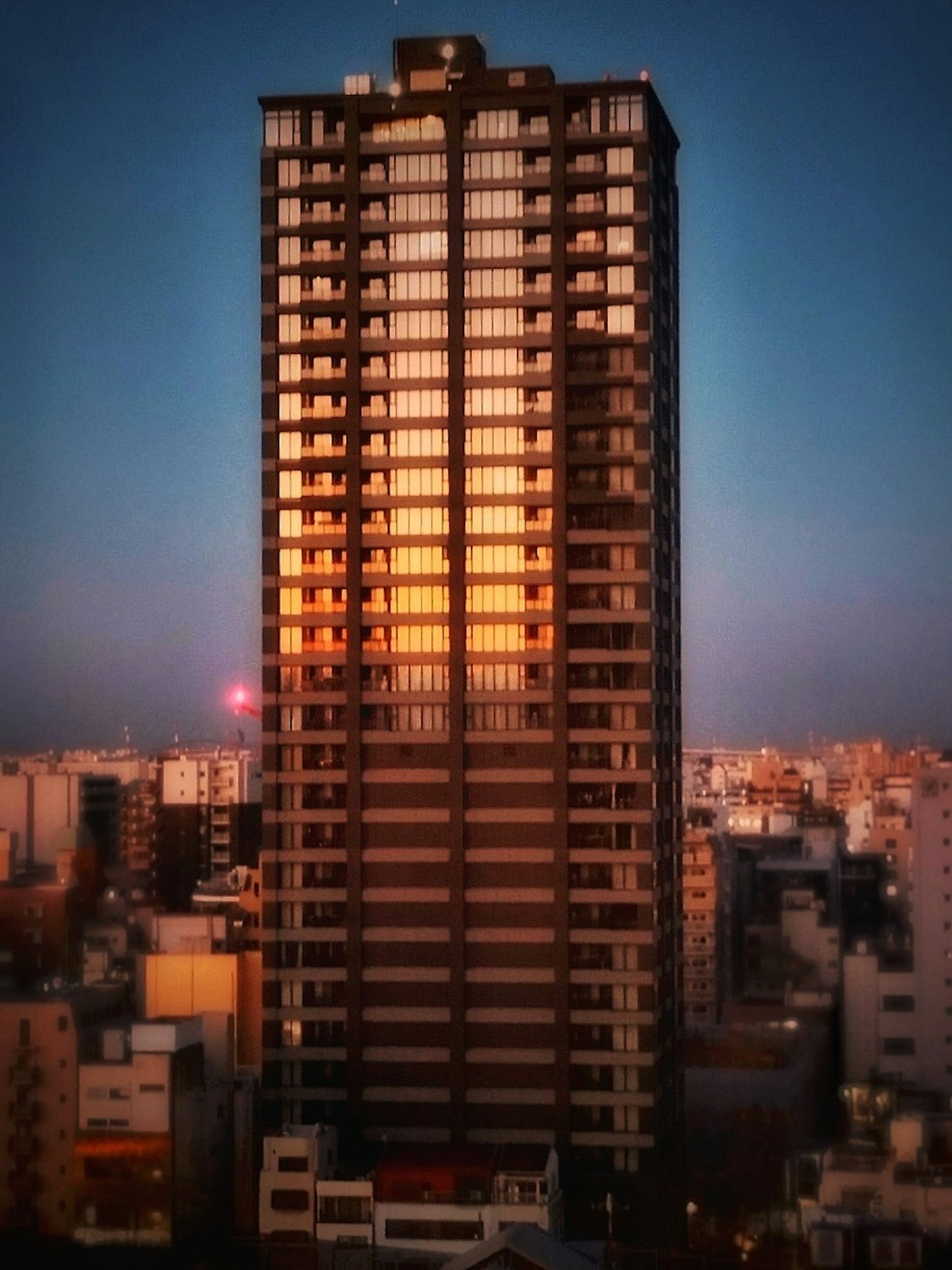 高楼大厦反射日落色彩的图像，周围是城市风景