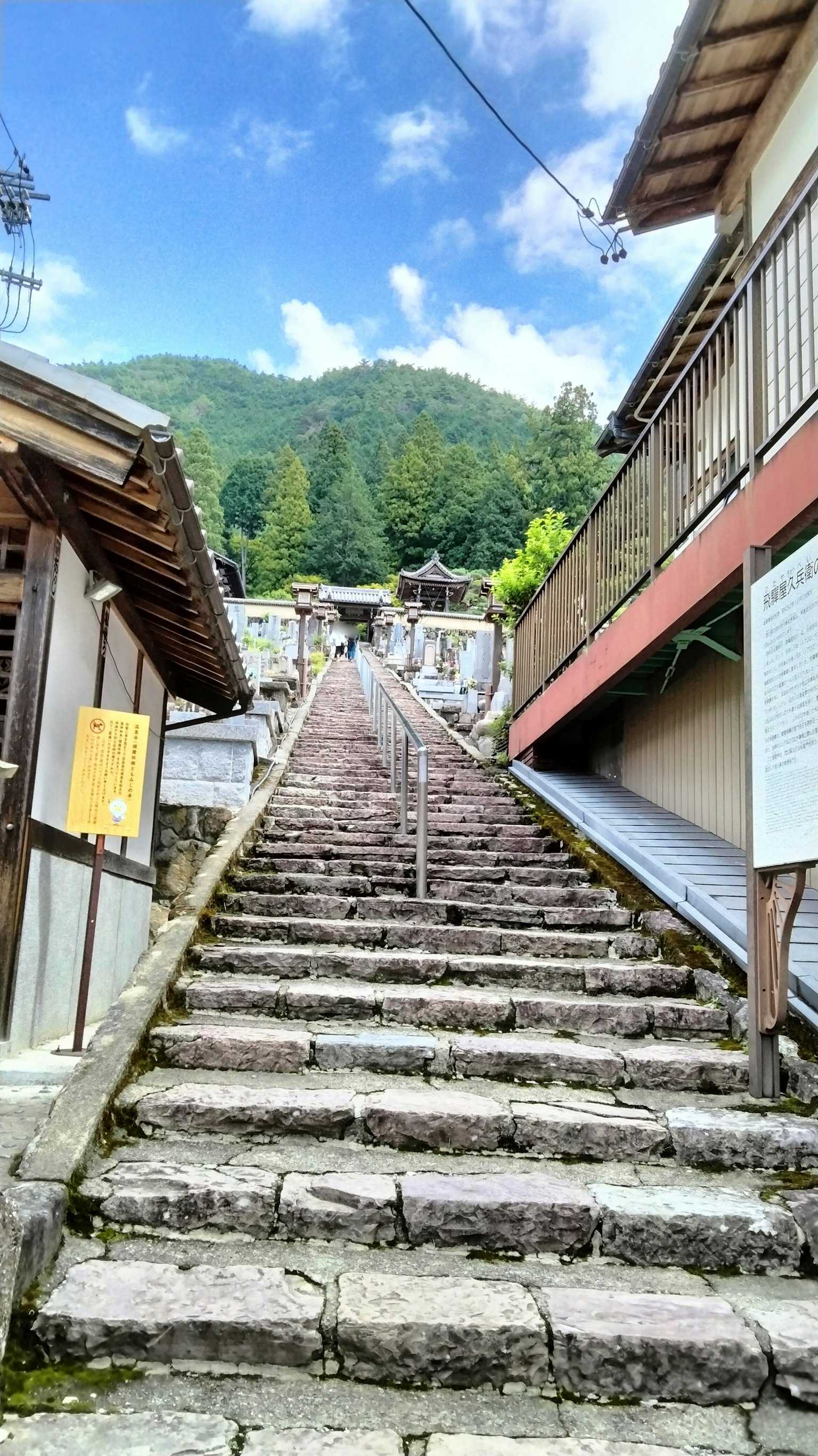 Stone steps leading up surrounded by traditional buildings and green mountains