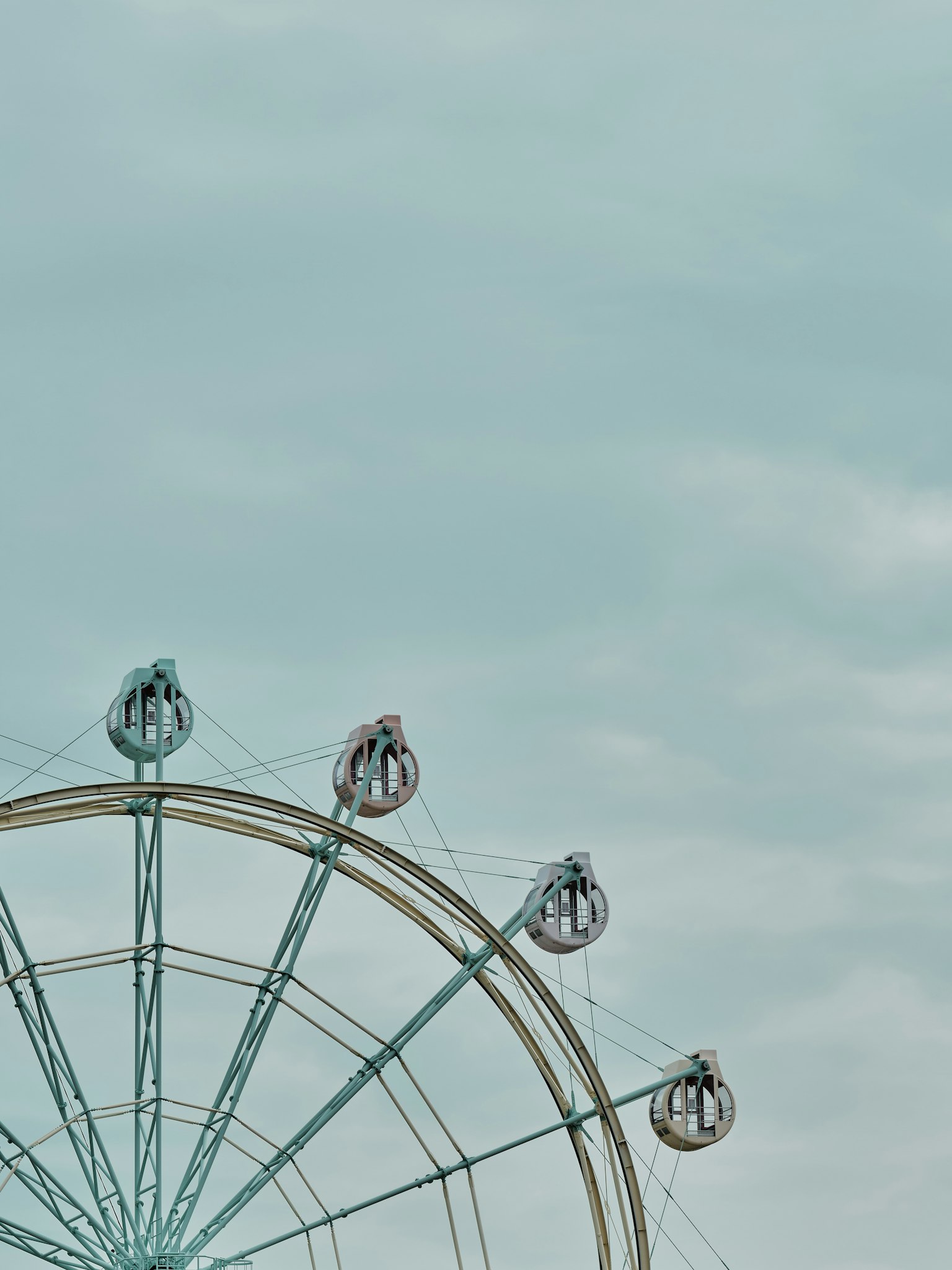Une partie d'une grande roue sous un ciel bleu