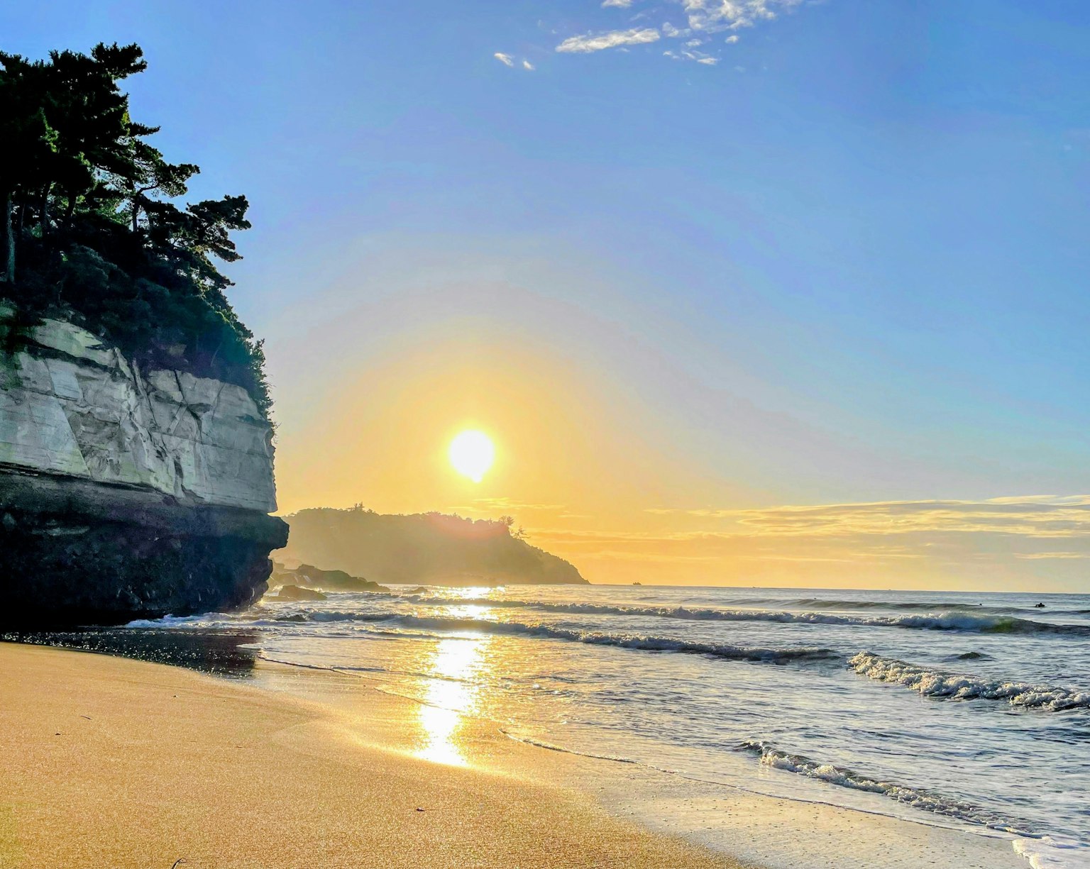 Pemandangan pantai yang indah dengan matahari terbenam di atas lautan