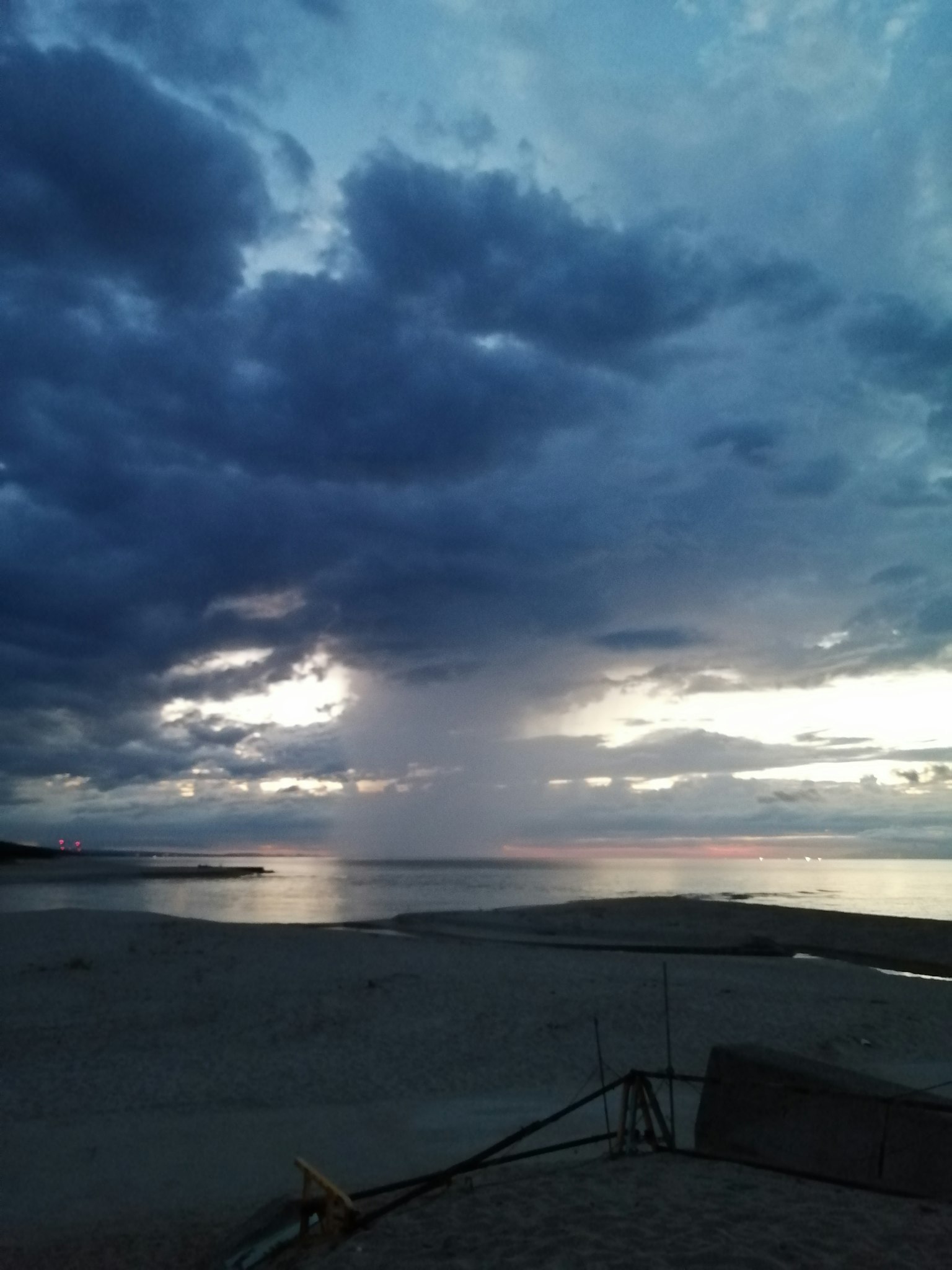 陰雲密布的寧靜海面上的戲劇性日落