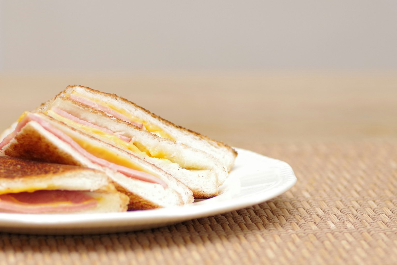Sandwich ham dan keju ditumpuk di piring