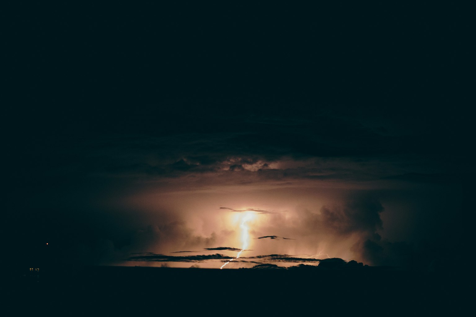 Cielo nocturno oscuro iluminado por un rayo entre las nubes