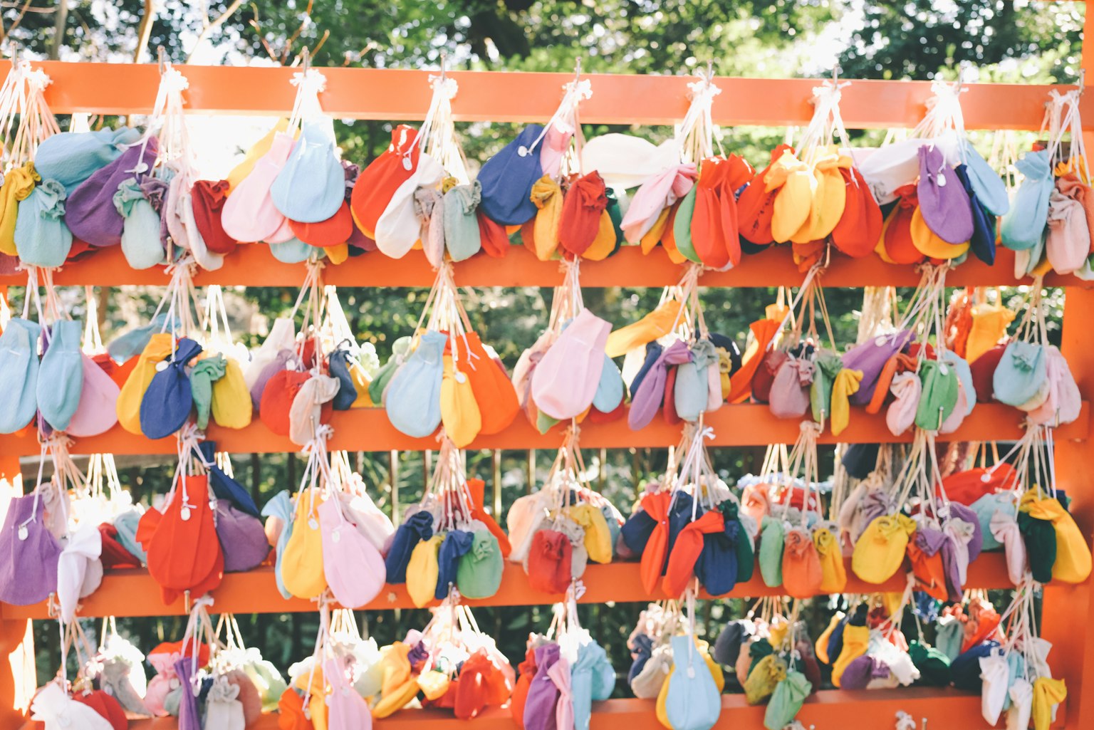 Piccole borse colorate appese a un muro arancione