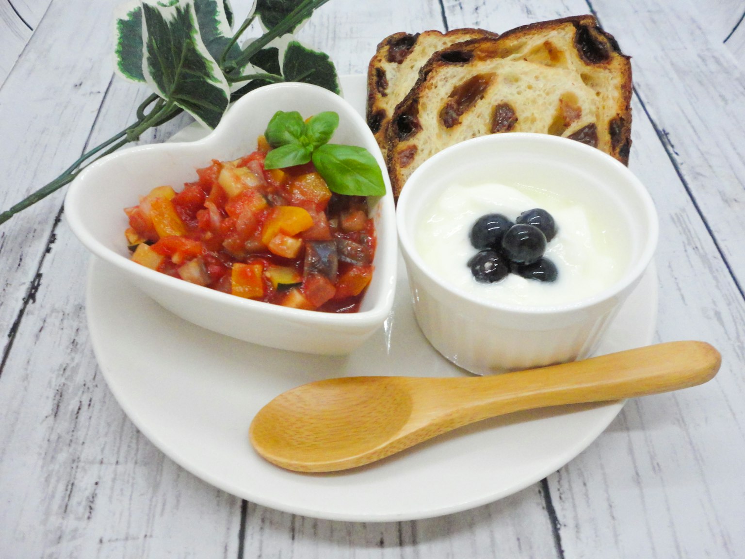 Assiette de petit-déjeuner avec un saladier en forme de cœur de salade de légumes yaourt et pain grillé