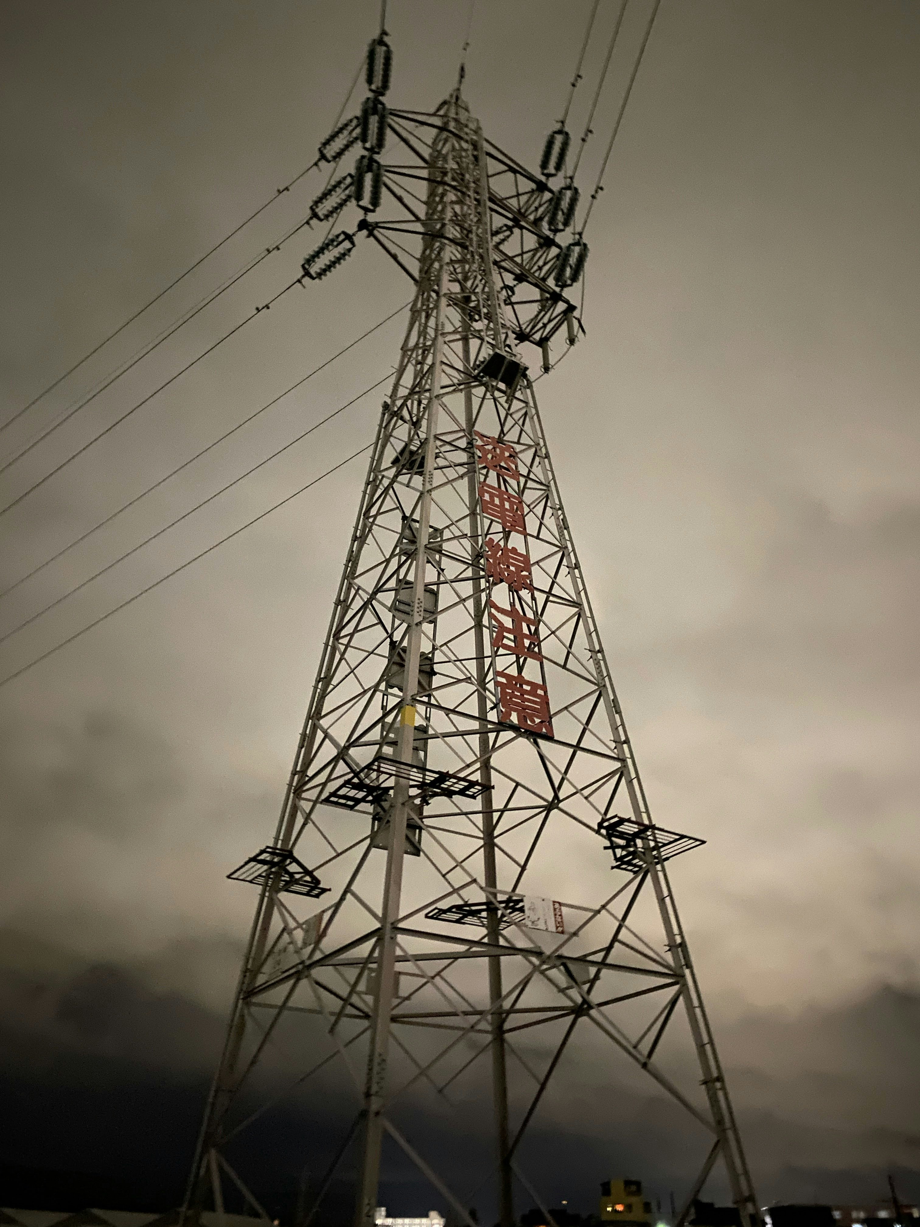 power transmission tower and overhead lines under cloudy sky