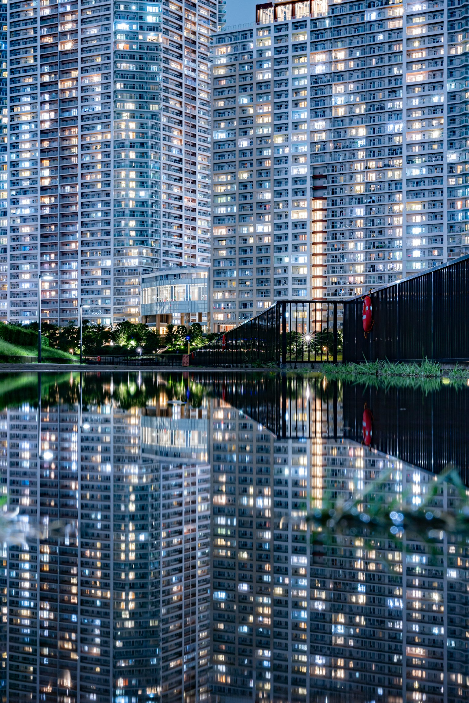 Vue nocturne de gratte-ciels se reflétant sur l'eau