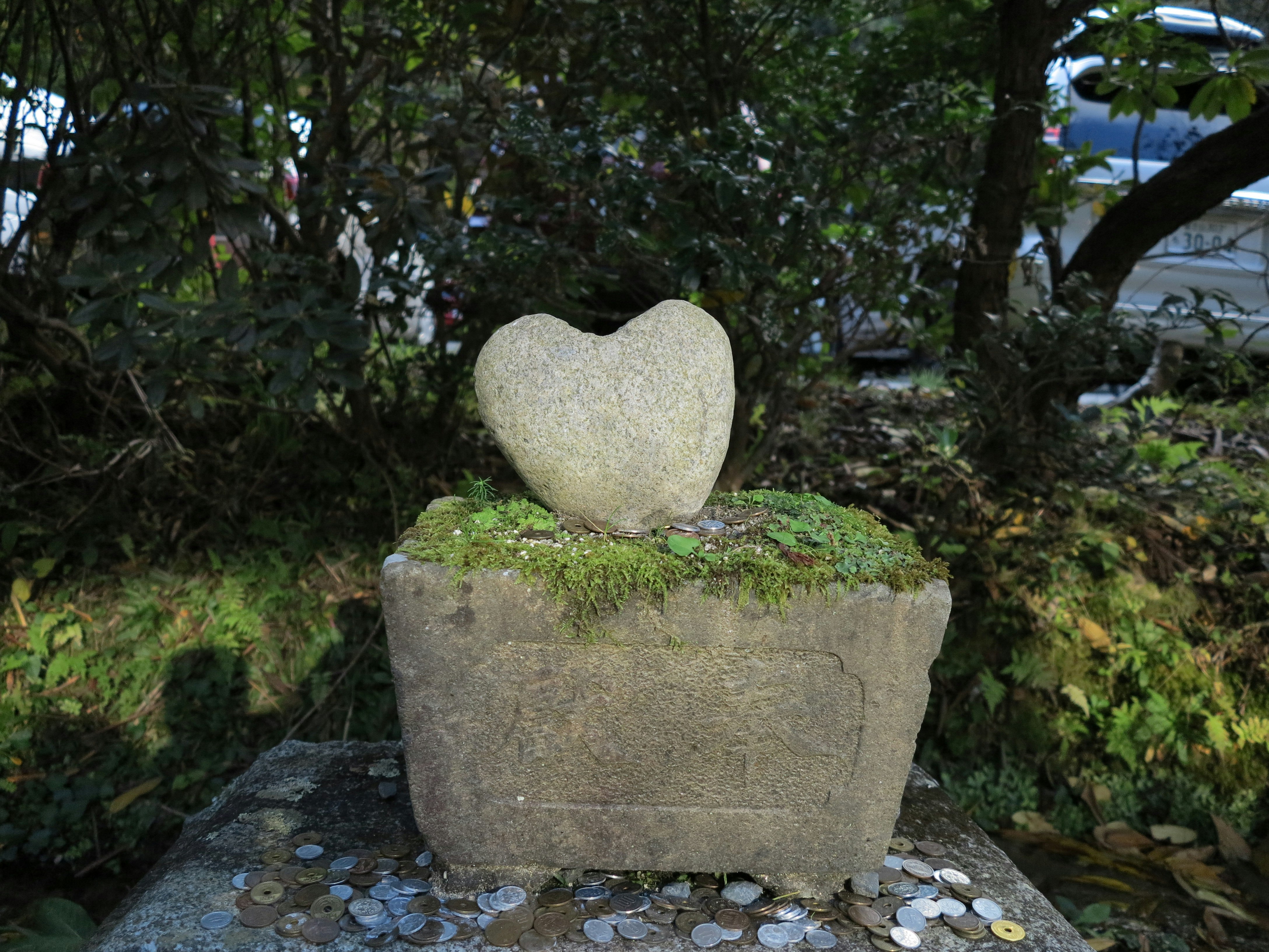 苔むした石の台座に置かれたハート形の石