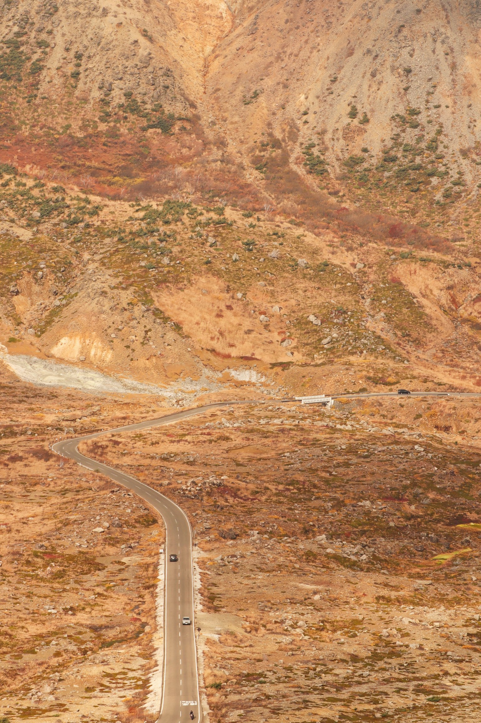 蜿蜒的道路穿過山脈，秋季色彩的風景