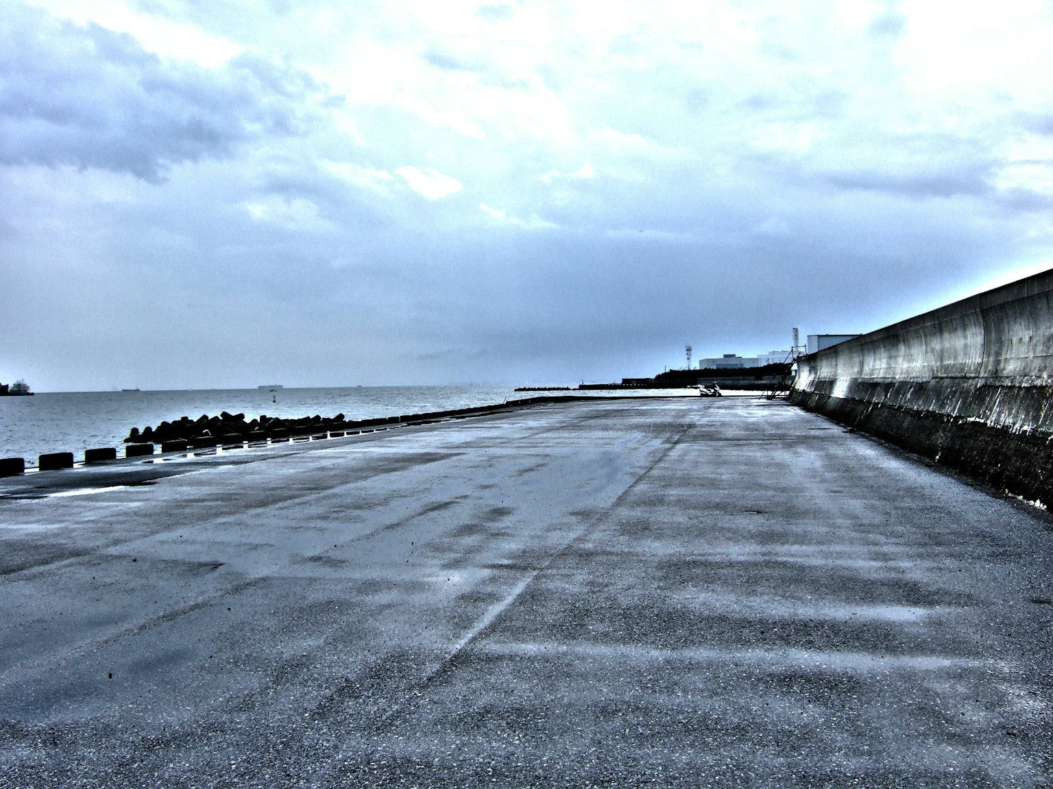 Scène côtière expansive avec ciel nuageux et mer calme