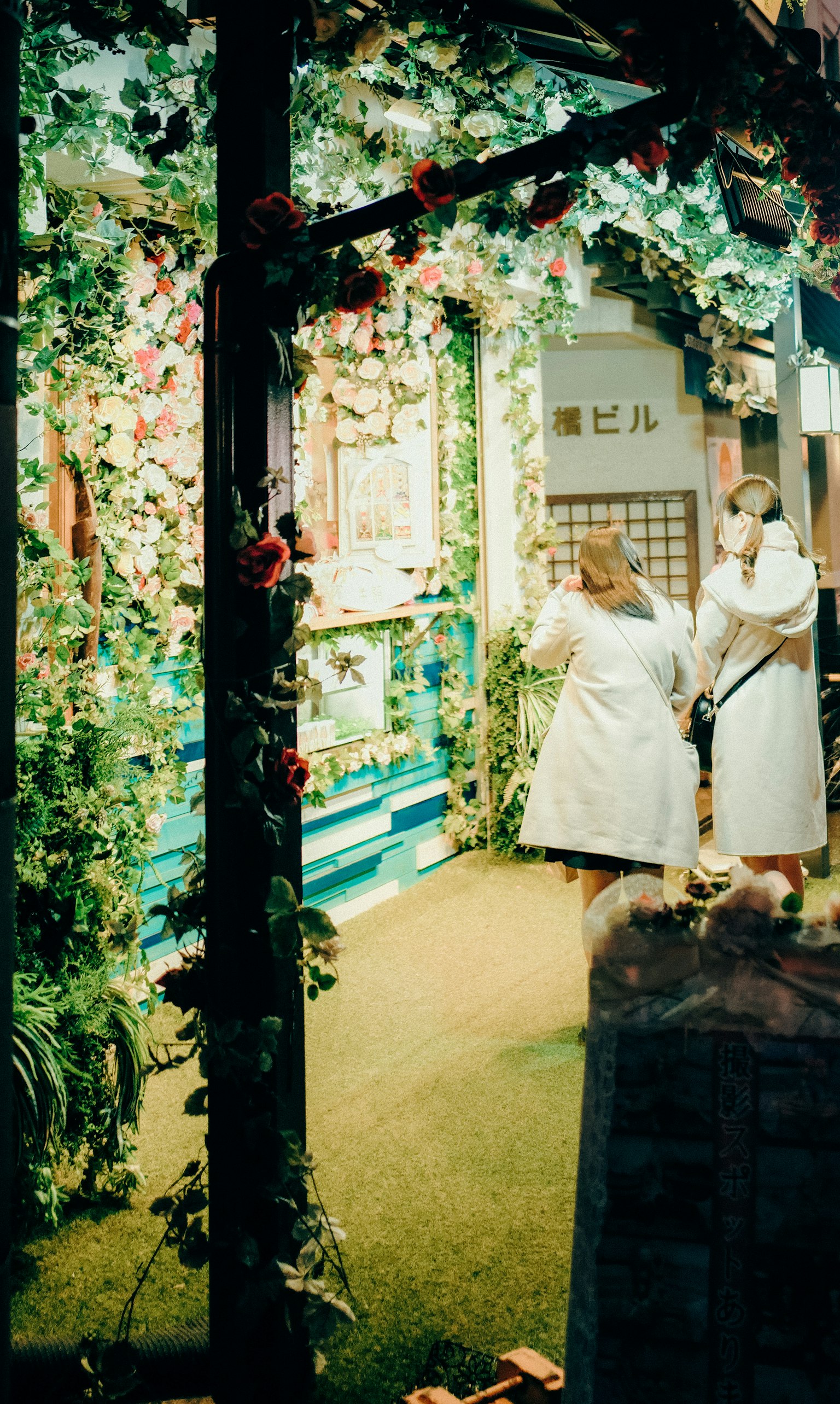 Dos mujeres de pie en una entrada decorada con flores