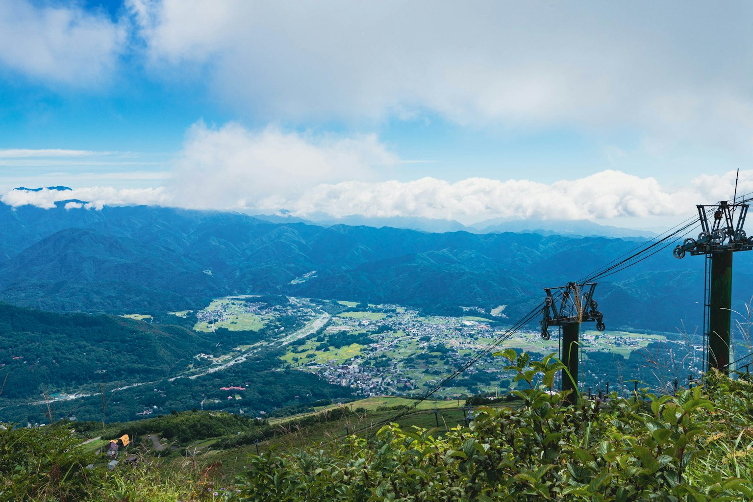 山頂的美麗景色 藍天和雲彩覆蓋著綠色山谷和小鎮